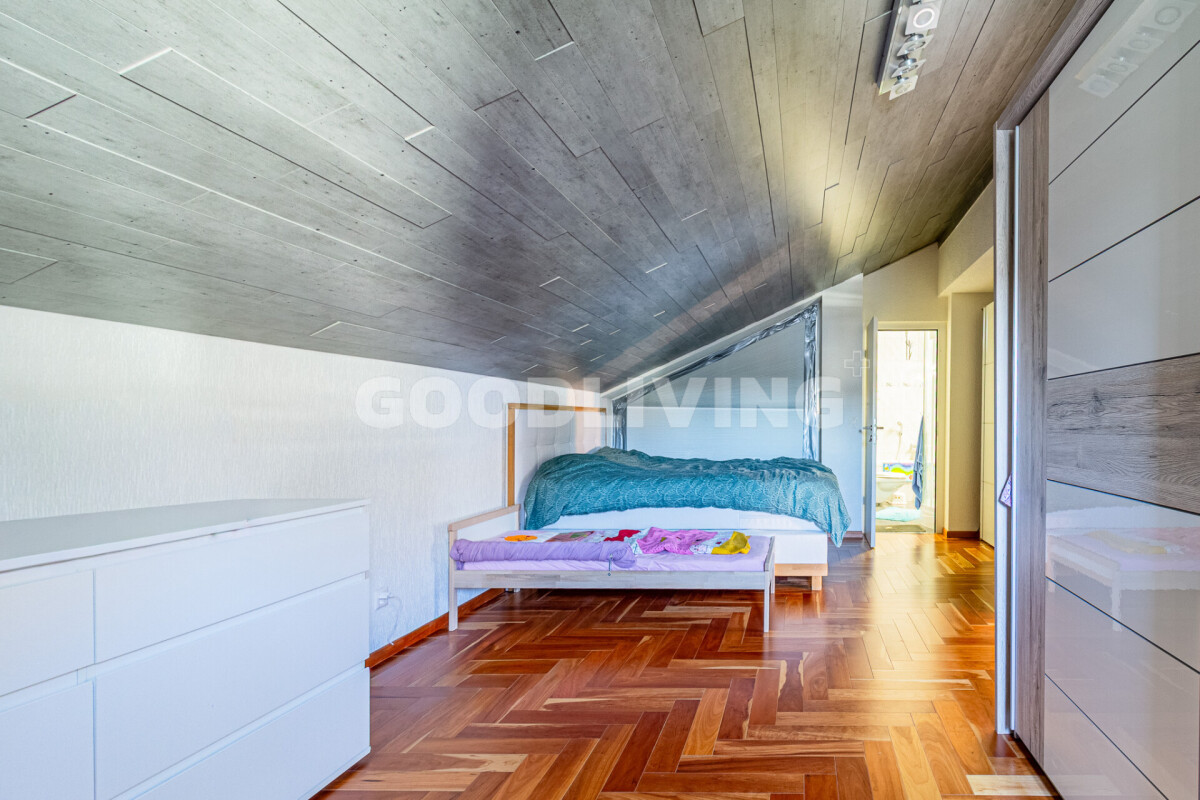 Dachgeschoss-Schlafzimmer mit Holzfußboden