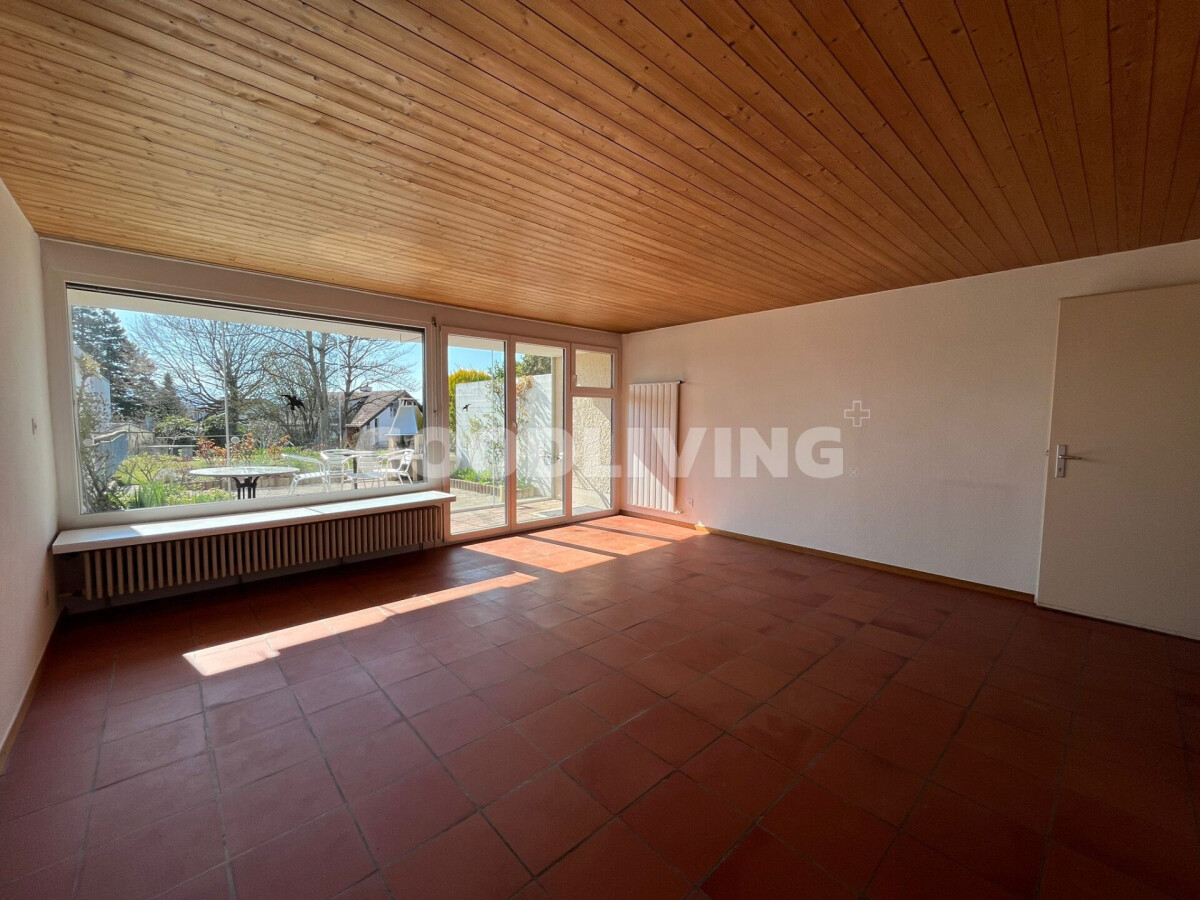 Heller Wohnraum mit Holzdecke und Blick in den Garten