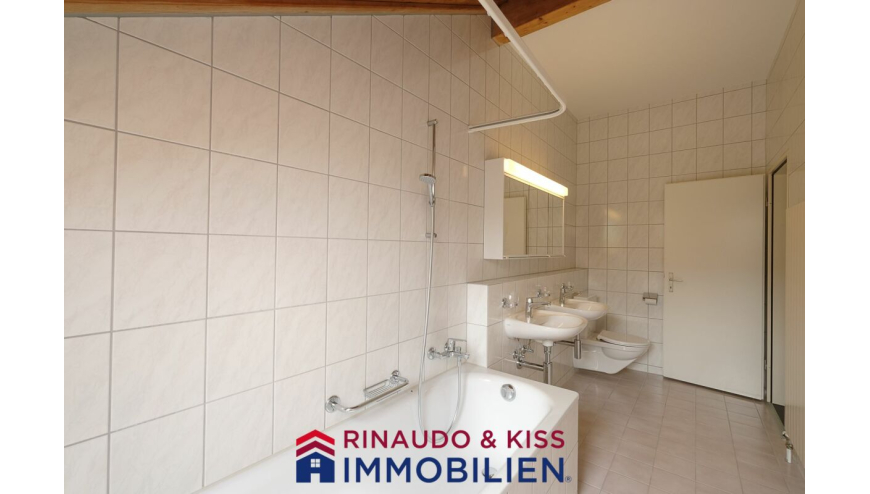 Badezimmer mit Badewanne und Doppelwaschbecken