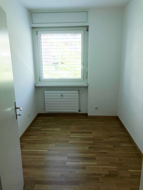 Leerer kleiner Raum mit Fenster und Heizkörper