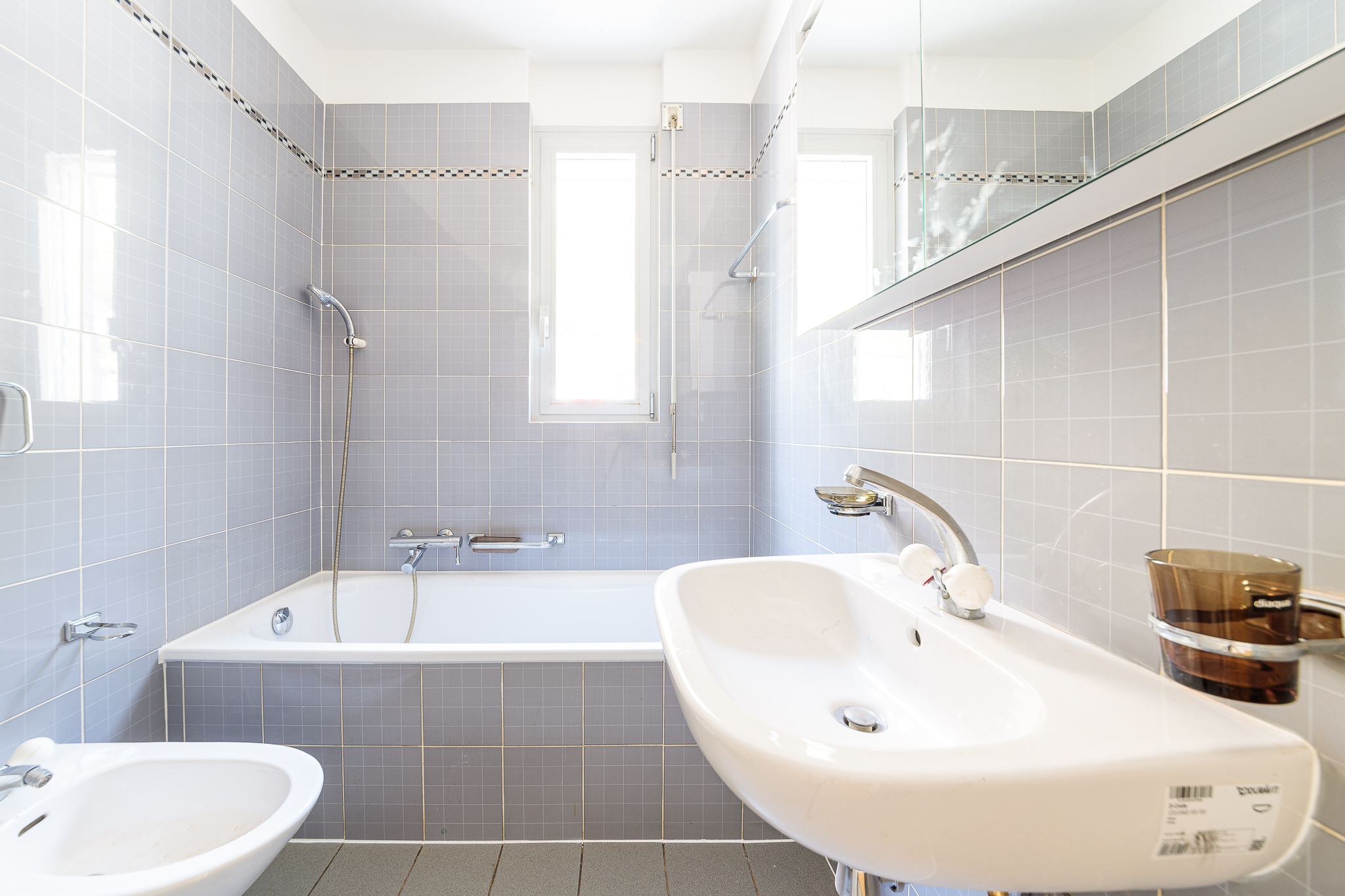 Badezimmer mit Badewanne und Doppelwaschtisch