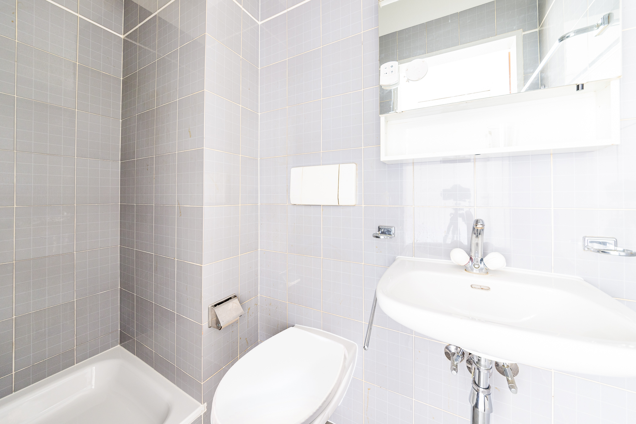 Kleines Badezimmer mit Badewanne und Waschbecken