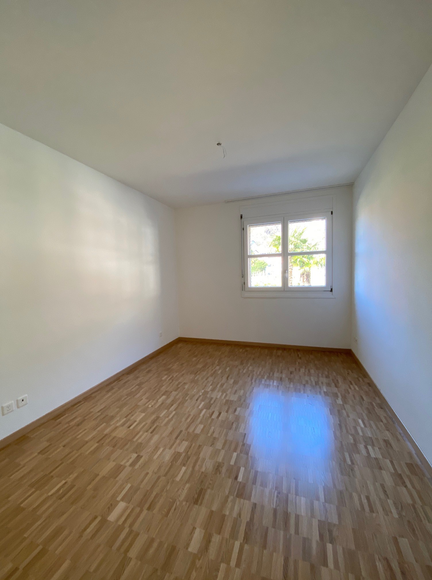 Leerer heller Raum mit Holzboden und Fenster