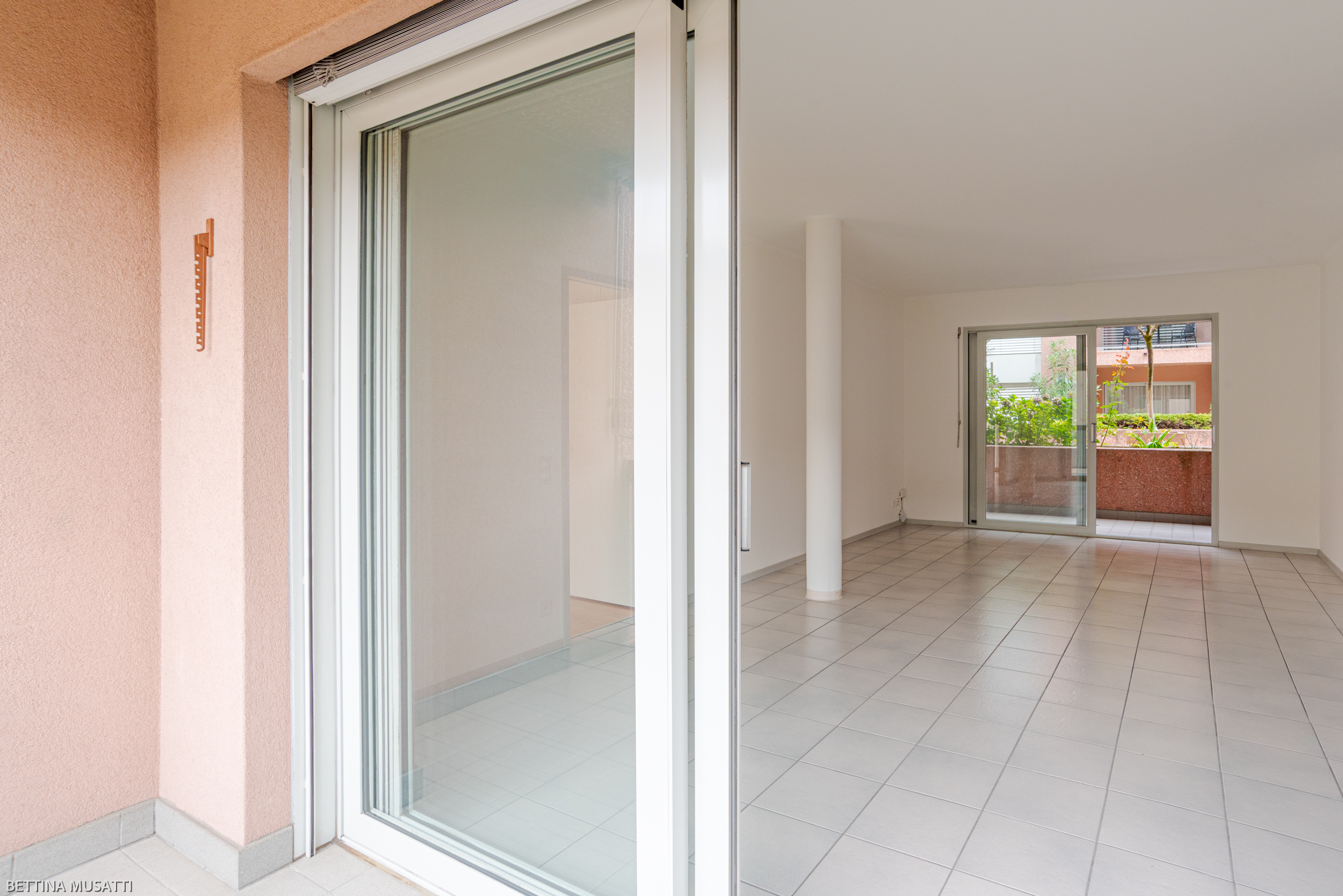 Helle, leere Wohnung mit Balkonzugang