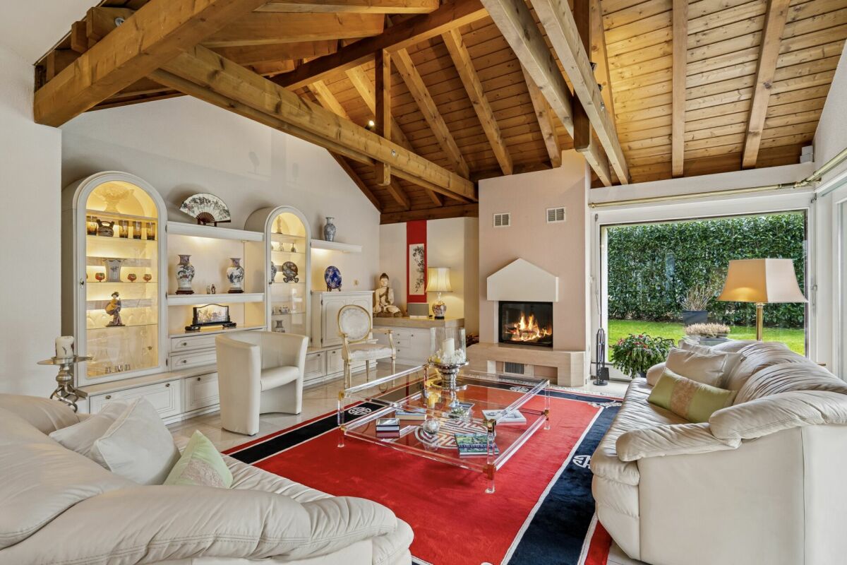 Wohnzimmer mit offenem Kamin und Gartenblick