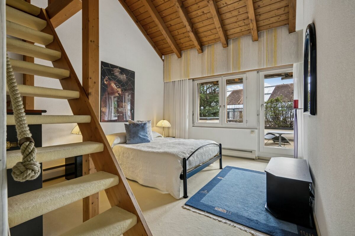Schlafzimmer mit Holztreppe und Dachschräge