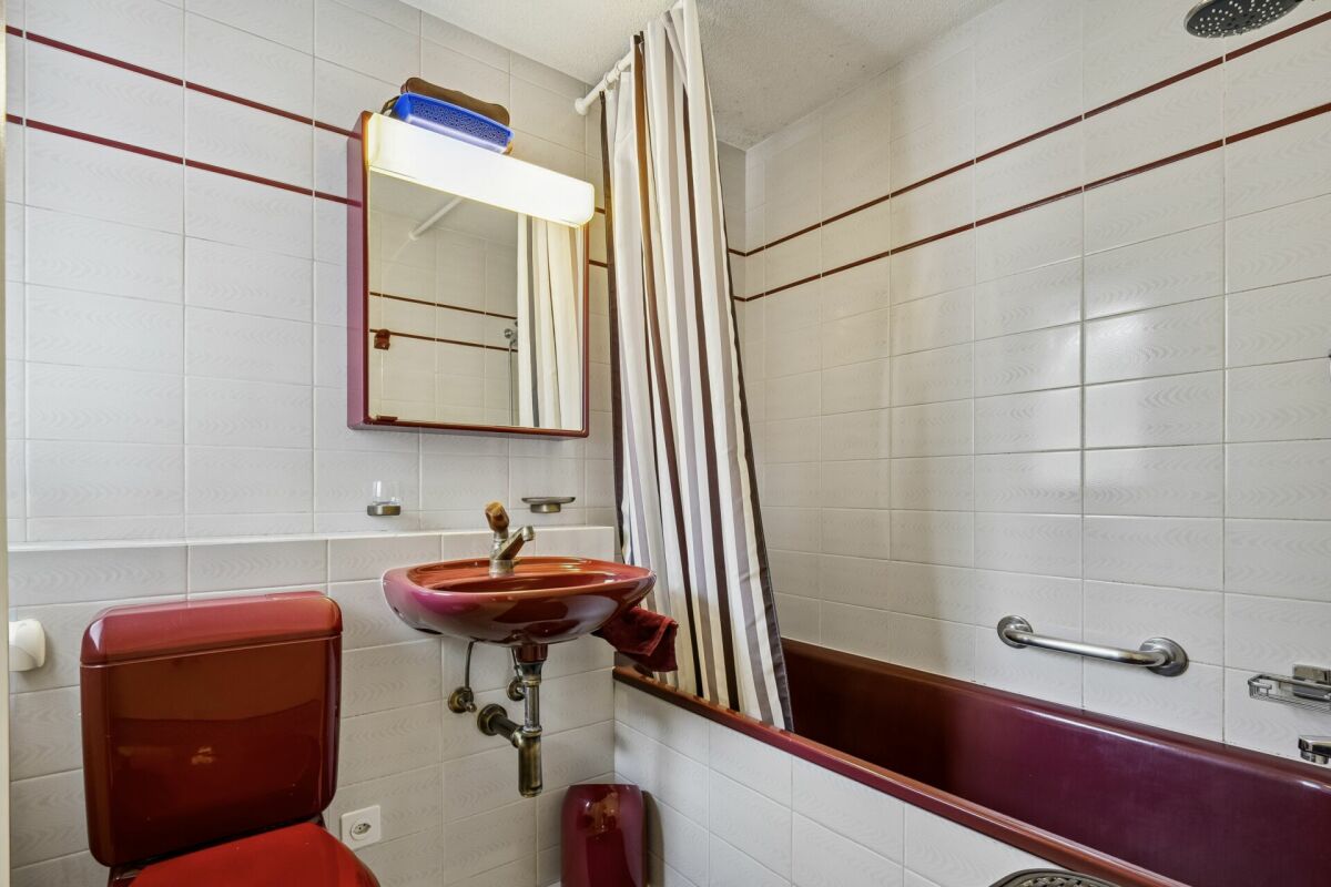 Badezimmer mit Badewanne und Farbdetails in Burgunderrot