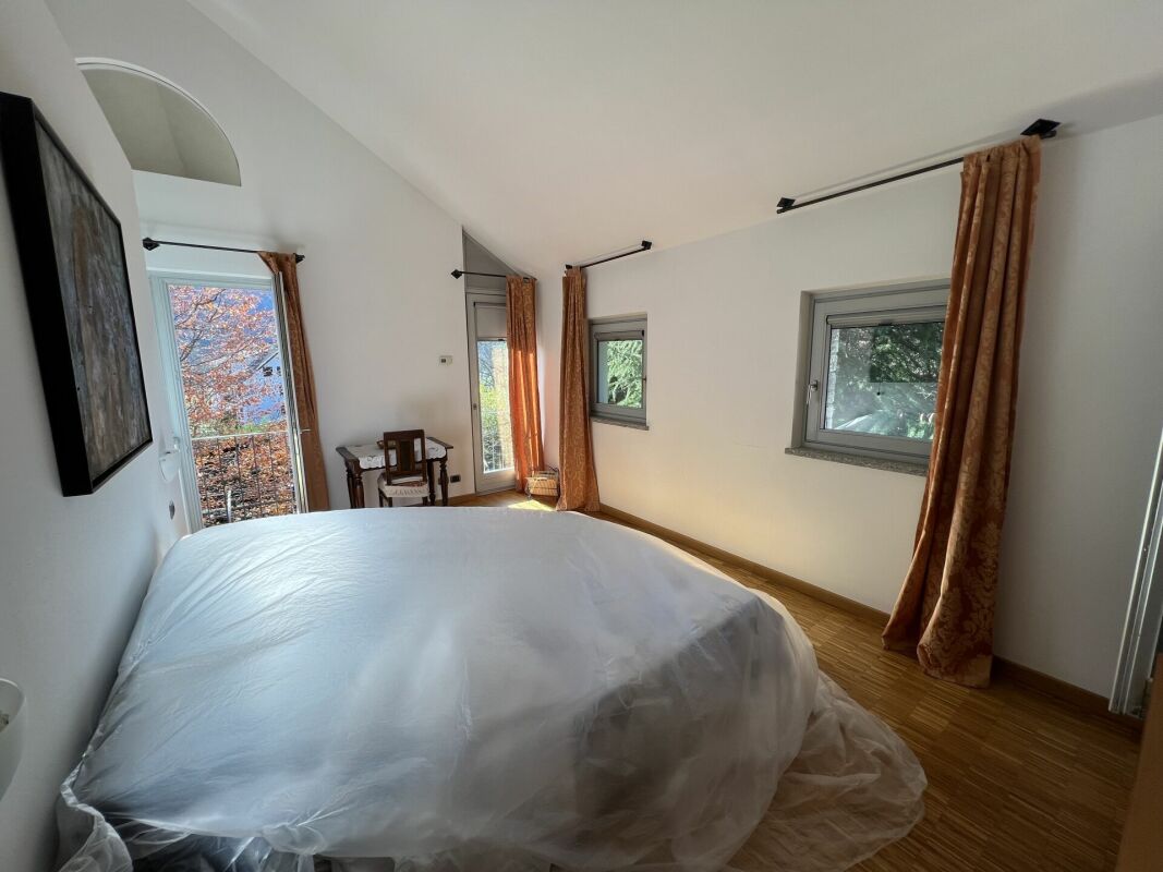 Helles Schlafzimmer mit Terrasse und mehreren Fenstern