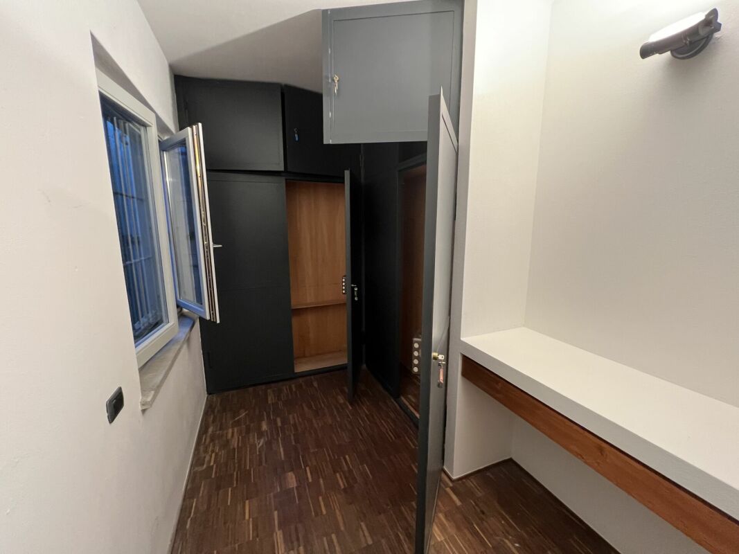 Kleiner Innenraum mit geöffnetem Fenster und eingebautem Schrank