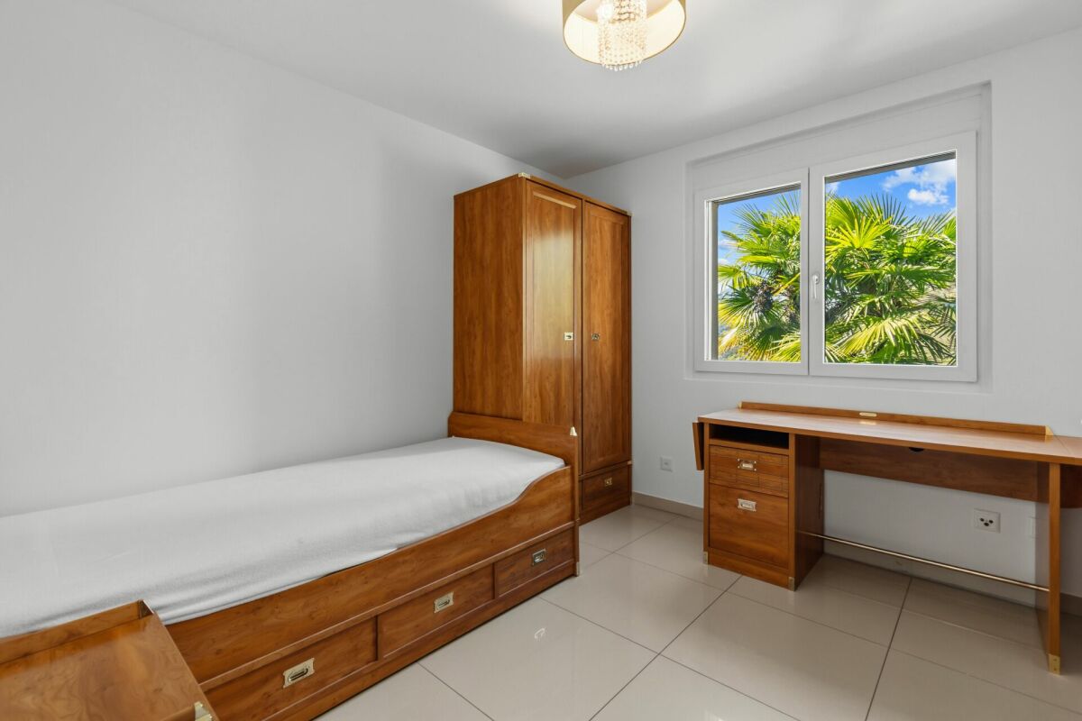 Helles Schlafzimmer mit Holzmöbeln und Blick ins Grüne