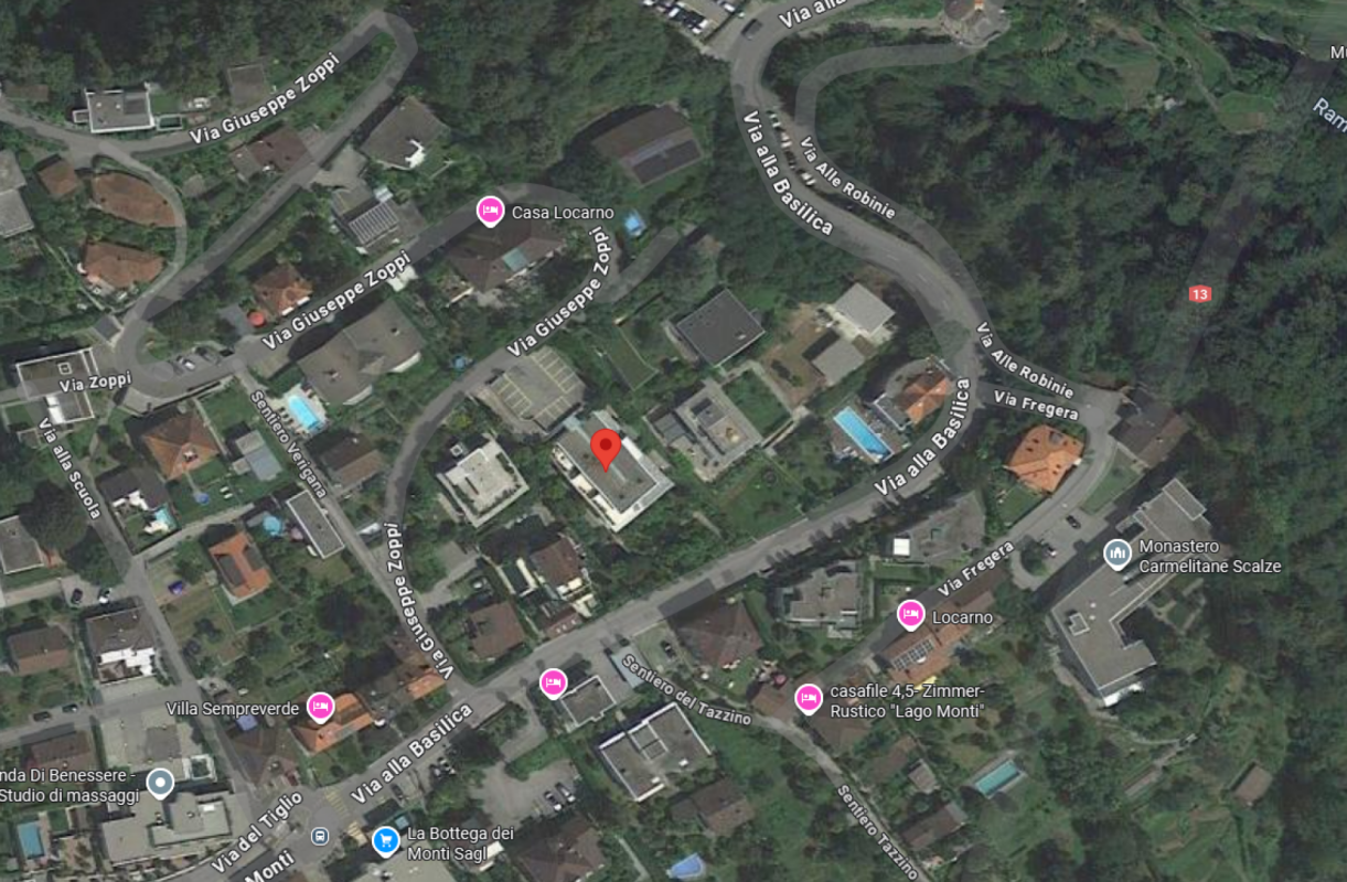 Satellitenansicht eines Wohngebiets in hügeliger, grüner Umgebung