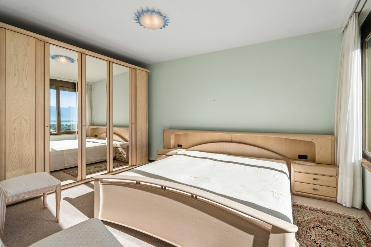 Helles Schlafzimmer mit Kleiderschrank und Bergblick