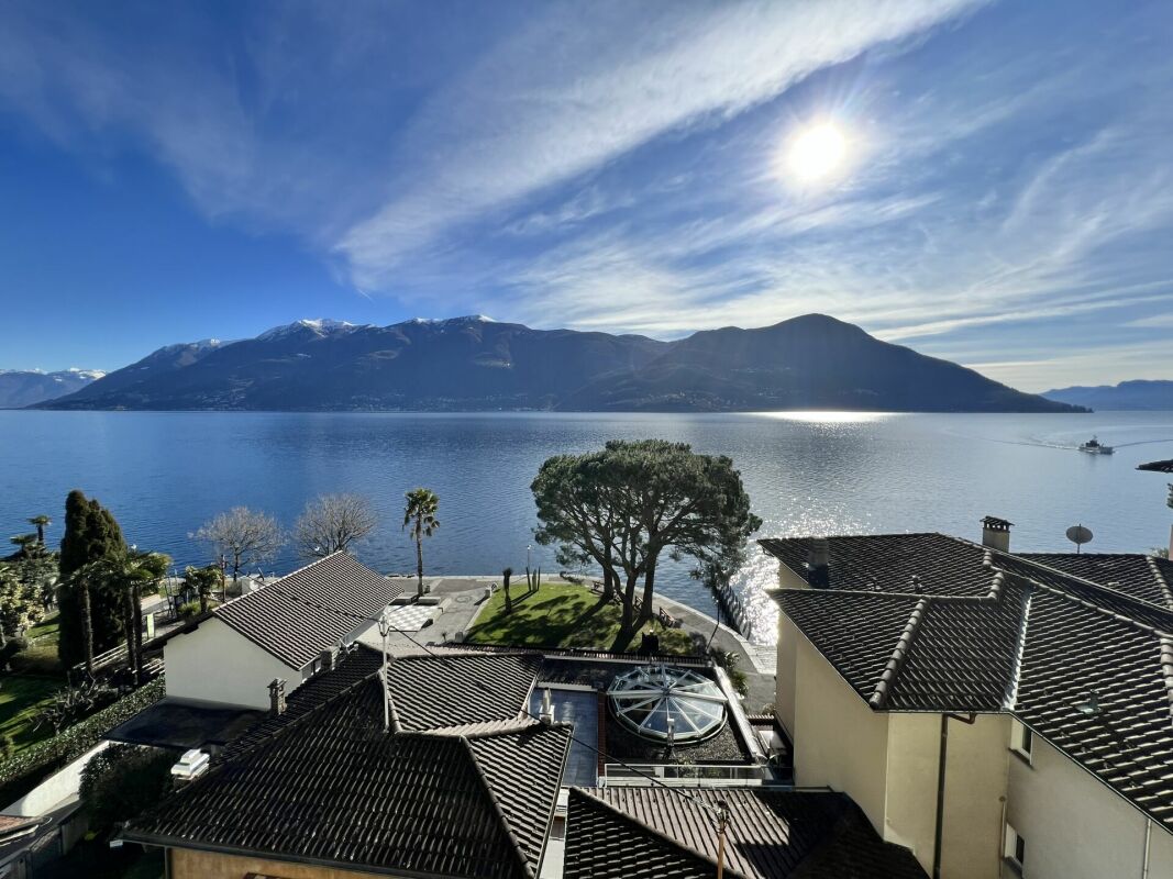 Seeblick mit Bergen und Dächer im Vordergrund