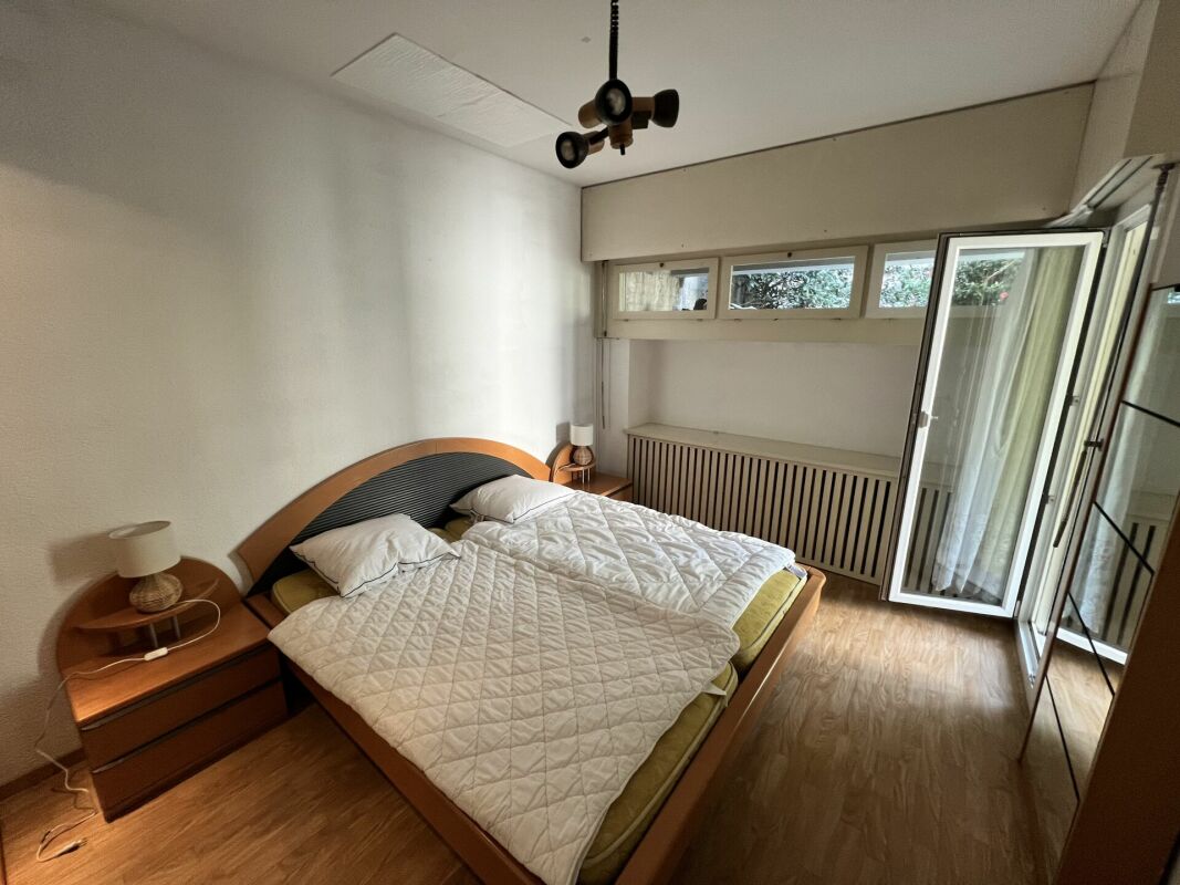 Helles Schlafzimmer mit Doppelbett und Balkonzugang