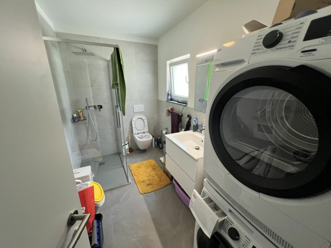 Badezimmer mit Dusche, WC, Waschtisch und Waschmaschine