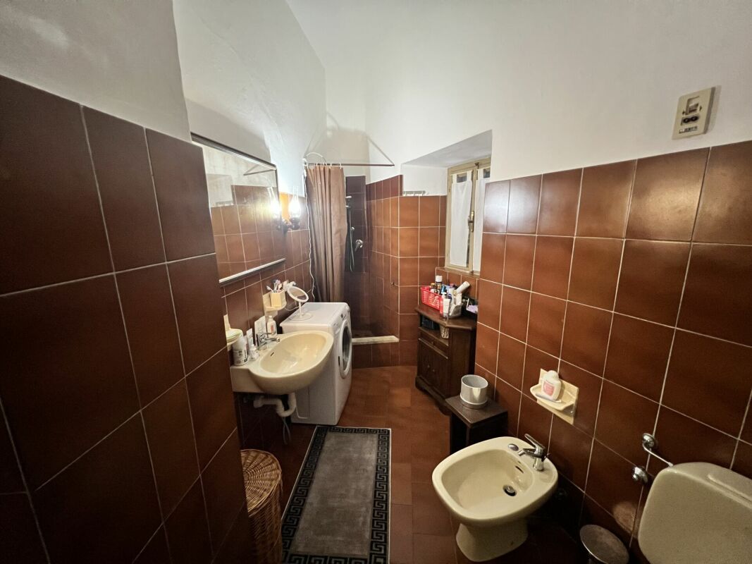 Badezimmer mit braunen Fliesen und Badmöbeln