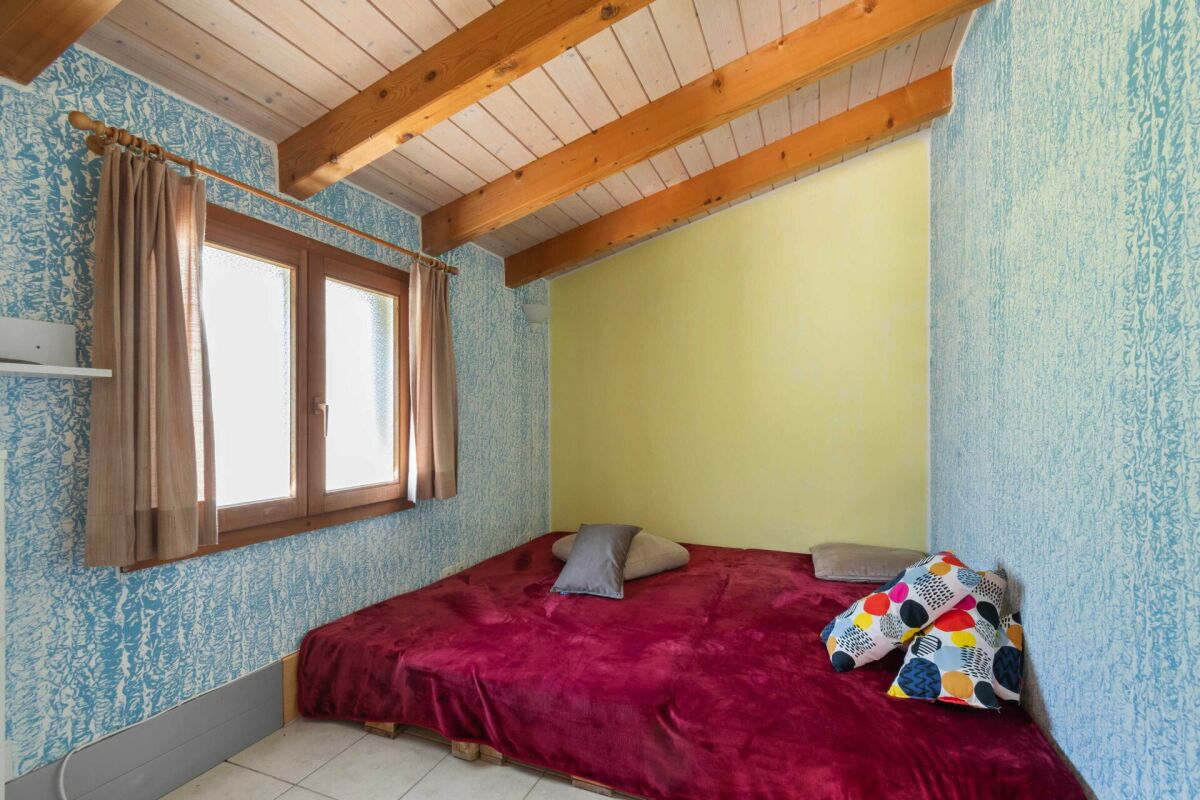 Kleines Schlafzimmer mit sichtbaren Holzbalken