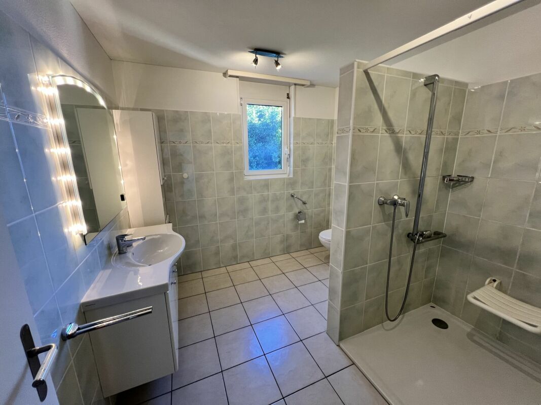Modernes Badezimmer mit Dusche und Fenster