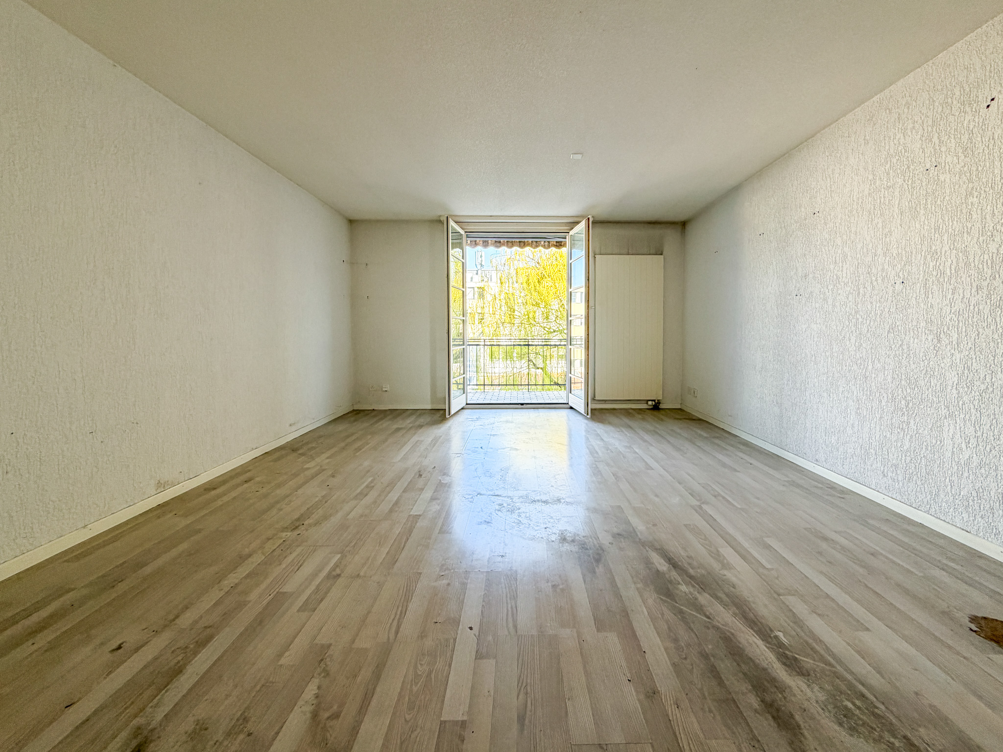 Leerer Wohnraum mit Balkonzugang