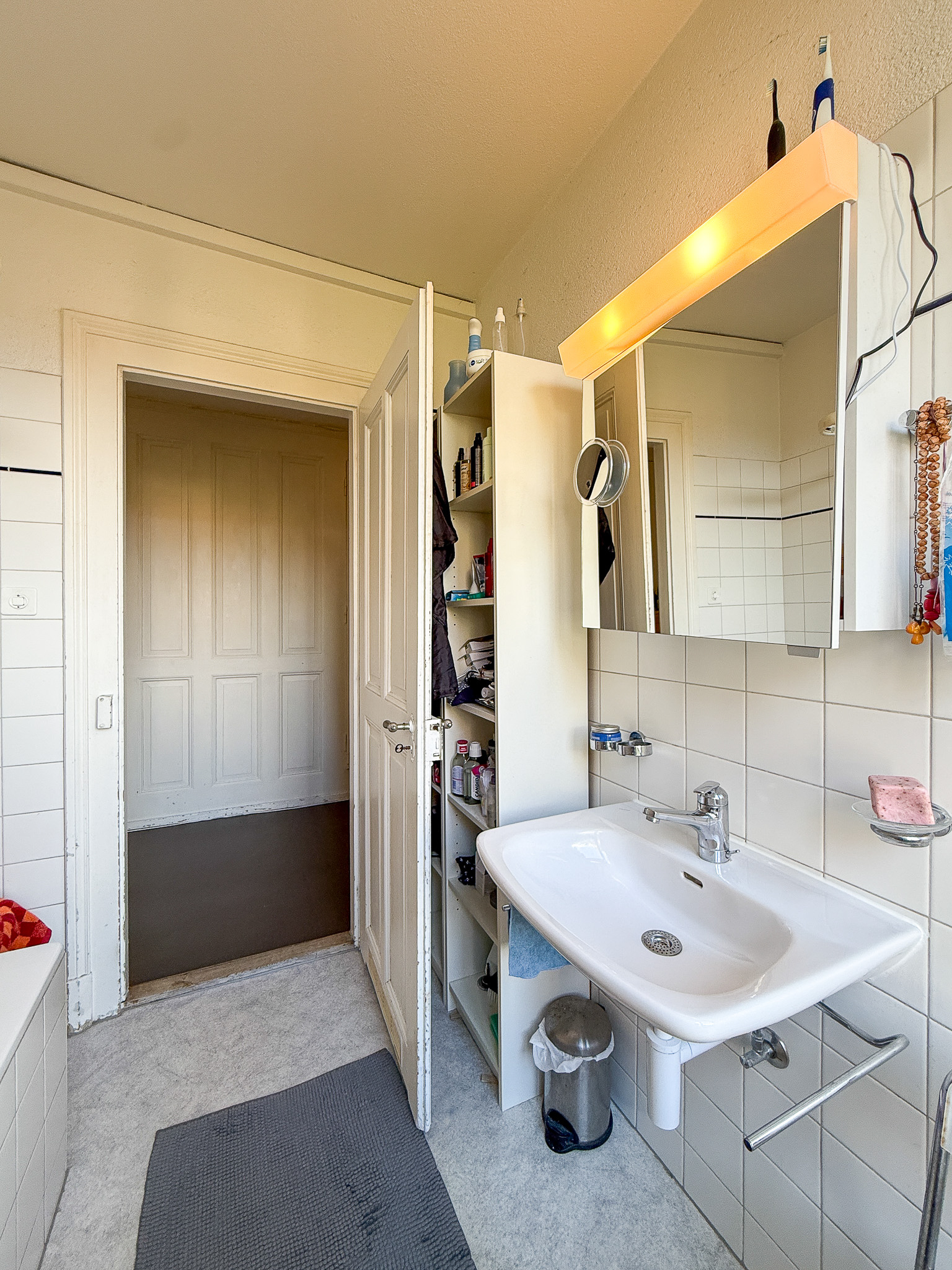 Badezimmer mit Waschbecken und Spiegelschrank