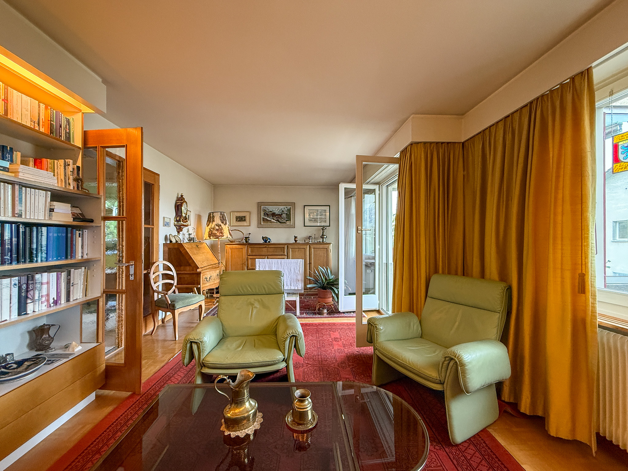 Wohnzimmer mit Bücherregal und klassischen Möbeln