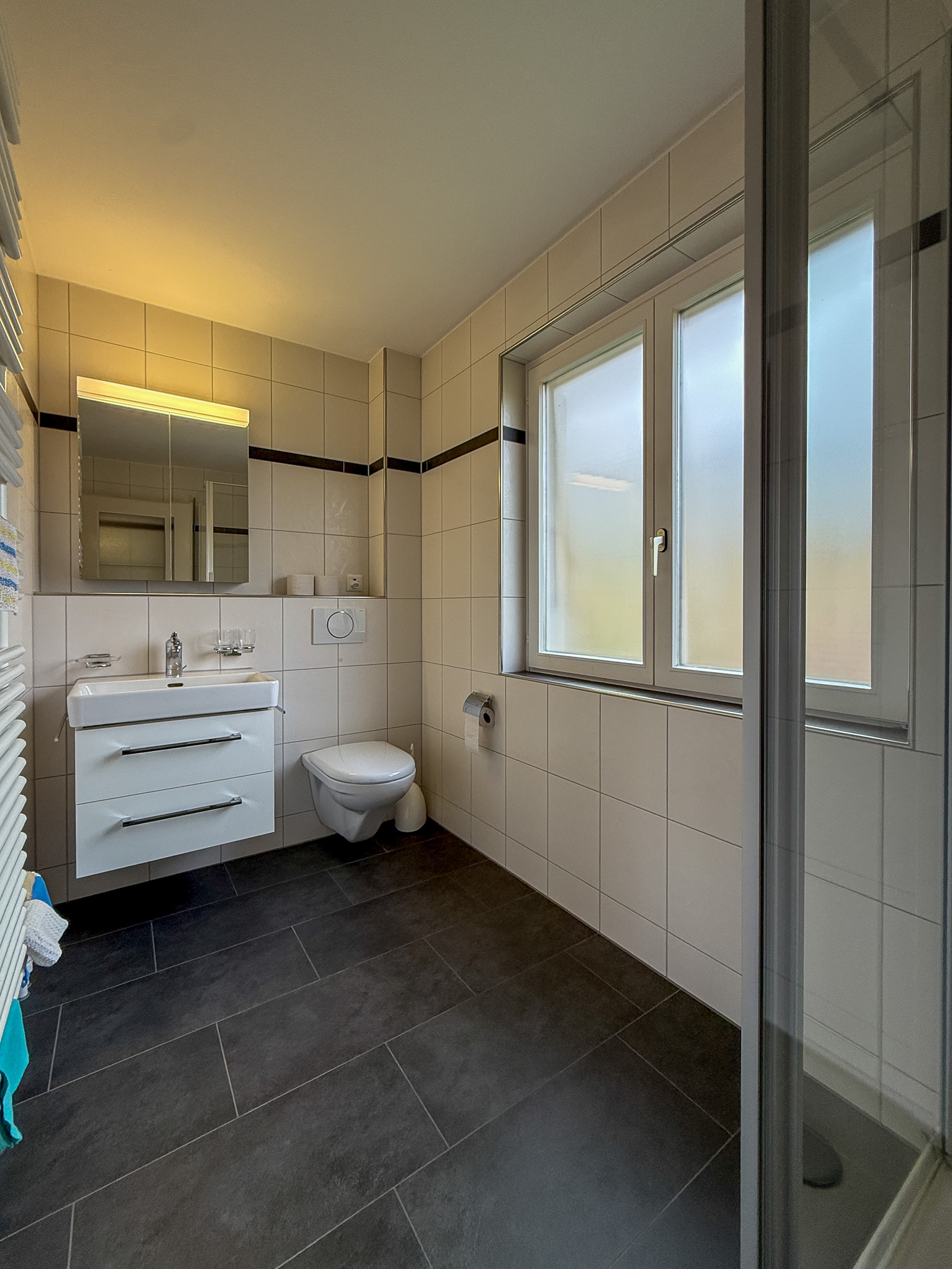 Modernes Badezimmer mit Fenster und WC