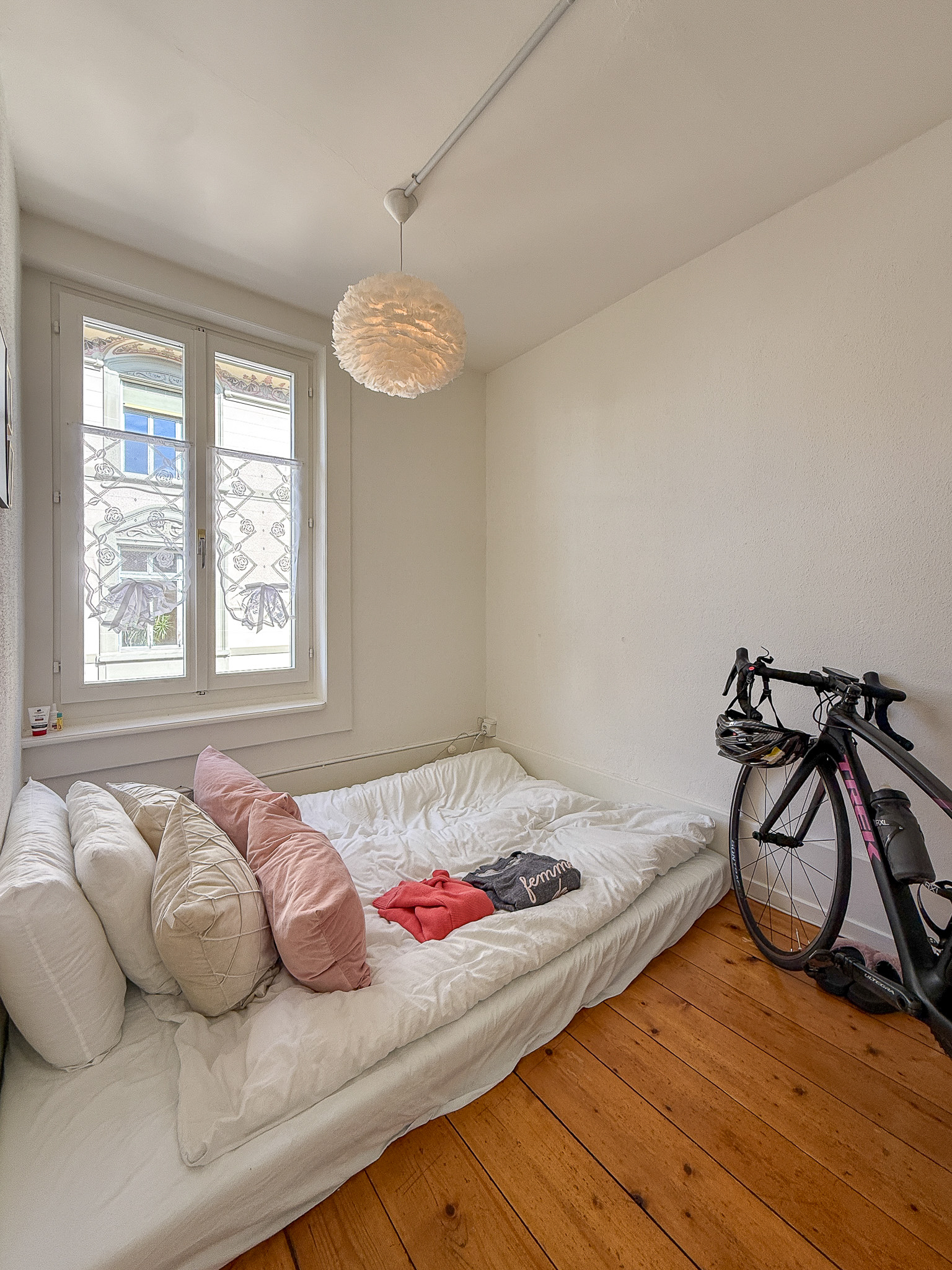 Kleines Schlafzimmer mit Bett und Fahrrad