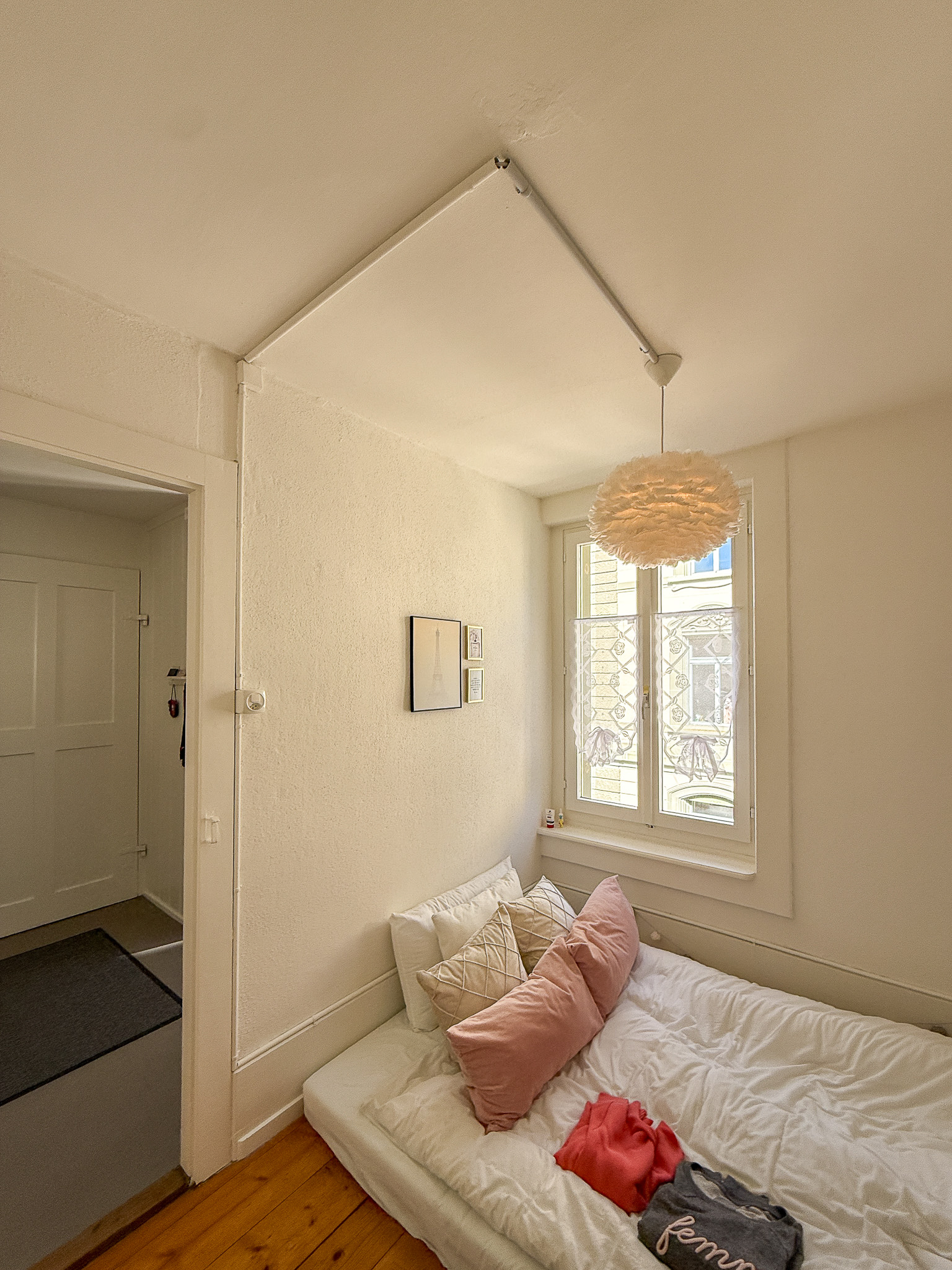 Kleines, helles Schlafzimmer mit Bett und Fenster