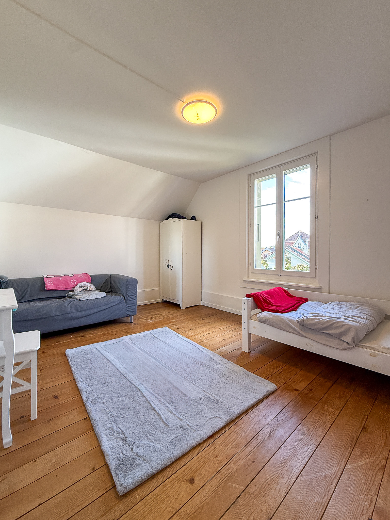 Dachgeschoss-Schlafzimmer mit einfacher Möblierung