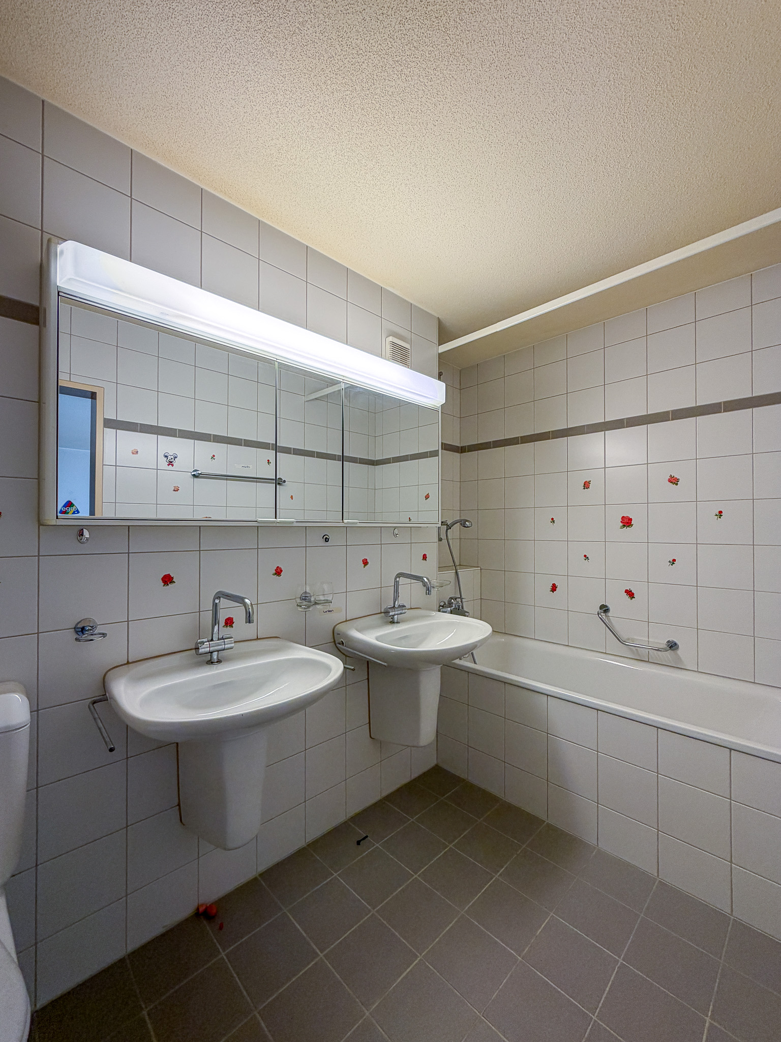 Badezimmer mit Doppelwaschbecken und Wannenbereich