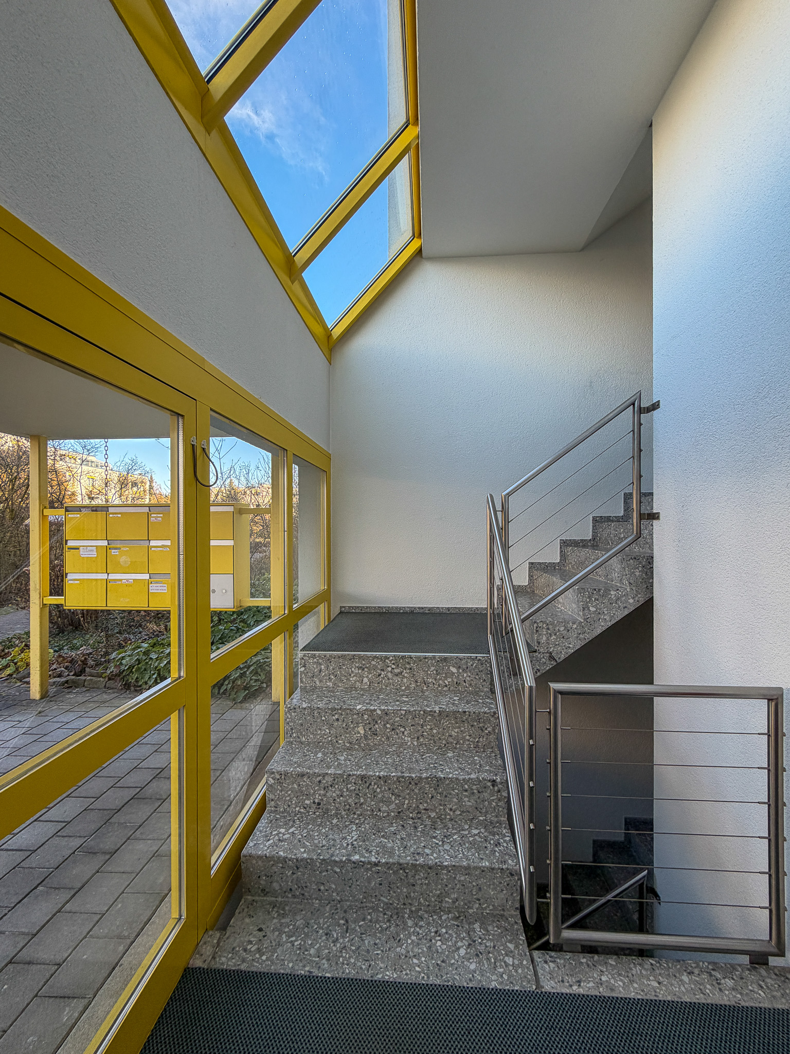 Treppenhaus mit gelben Fensterrahmen