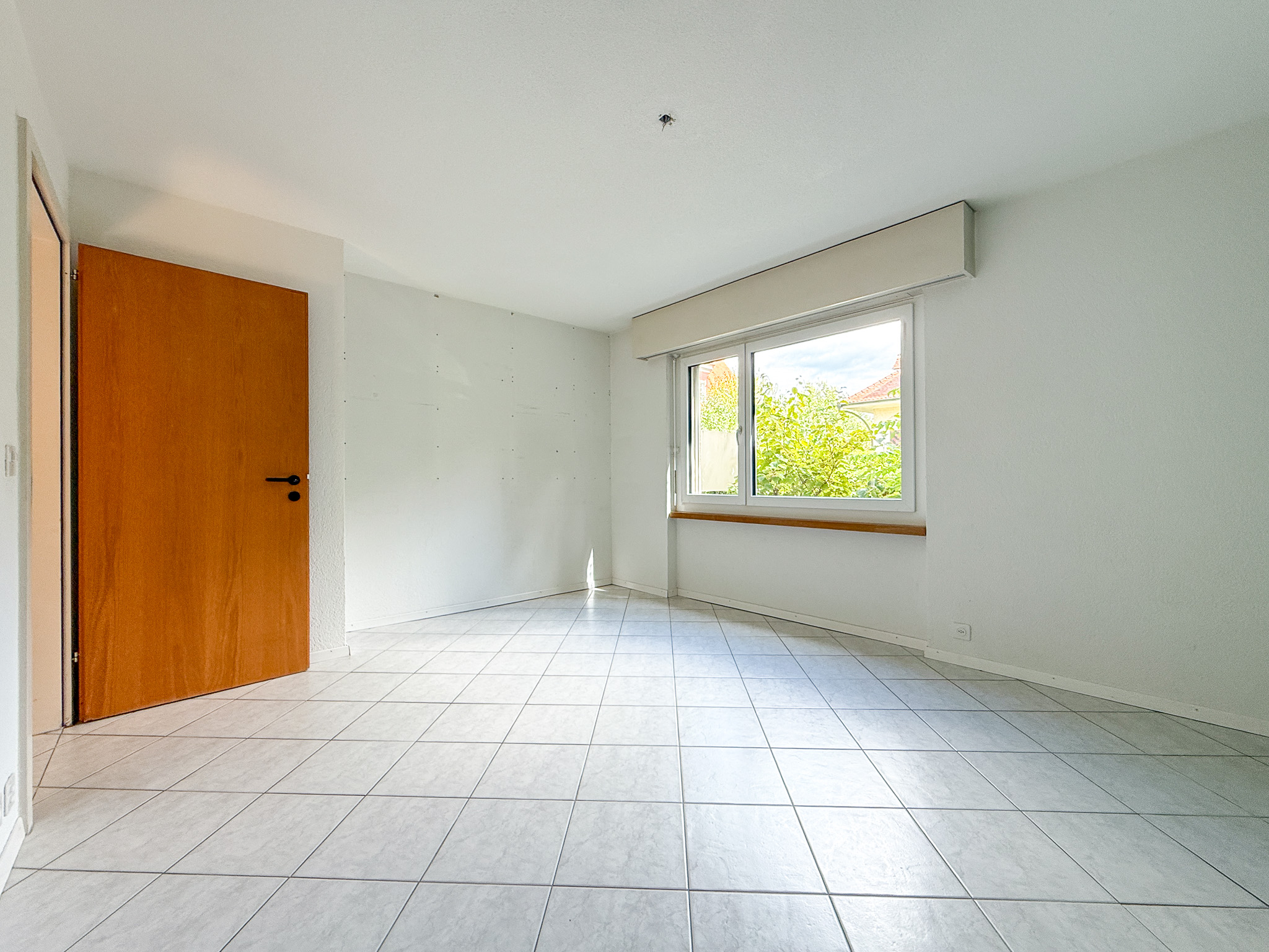 Leerer Raum mit Fliesenboden und Fenster