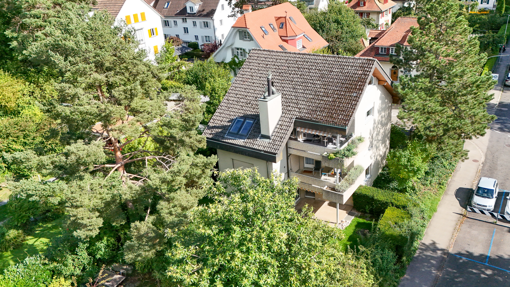 Außenansicht eines Wohnhauses mit Balkon und Garten