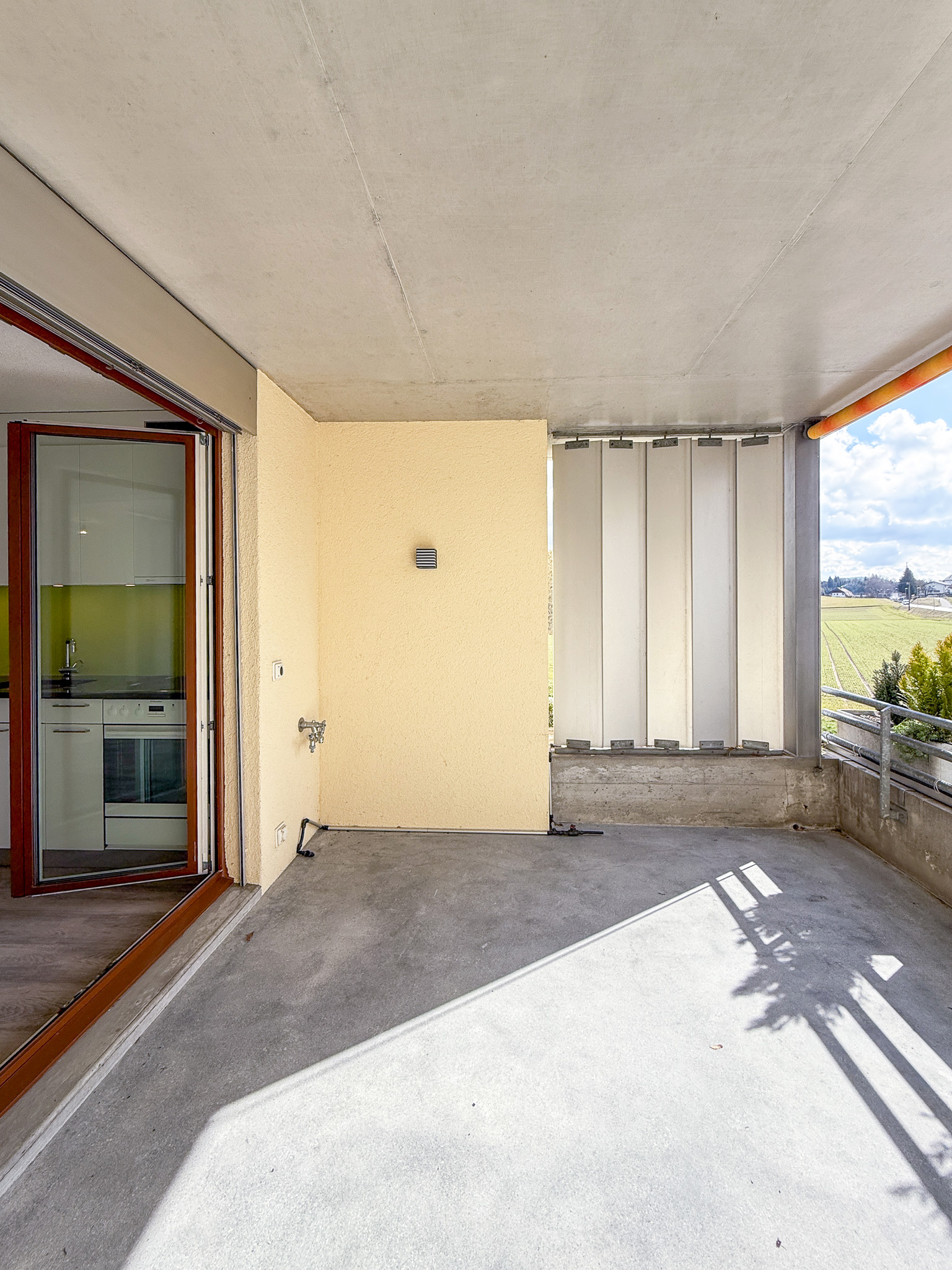 Überdachter Balkon mit Blick ins Grüne