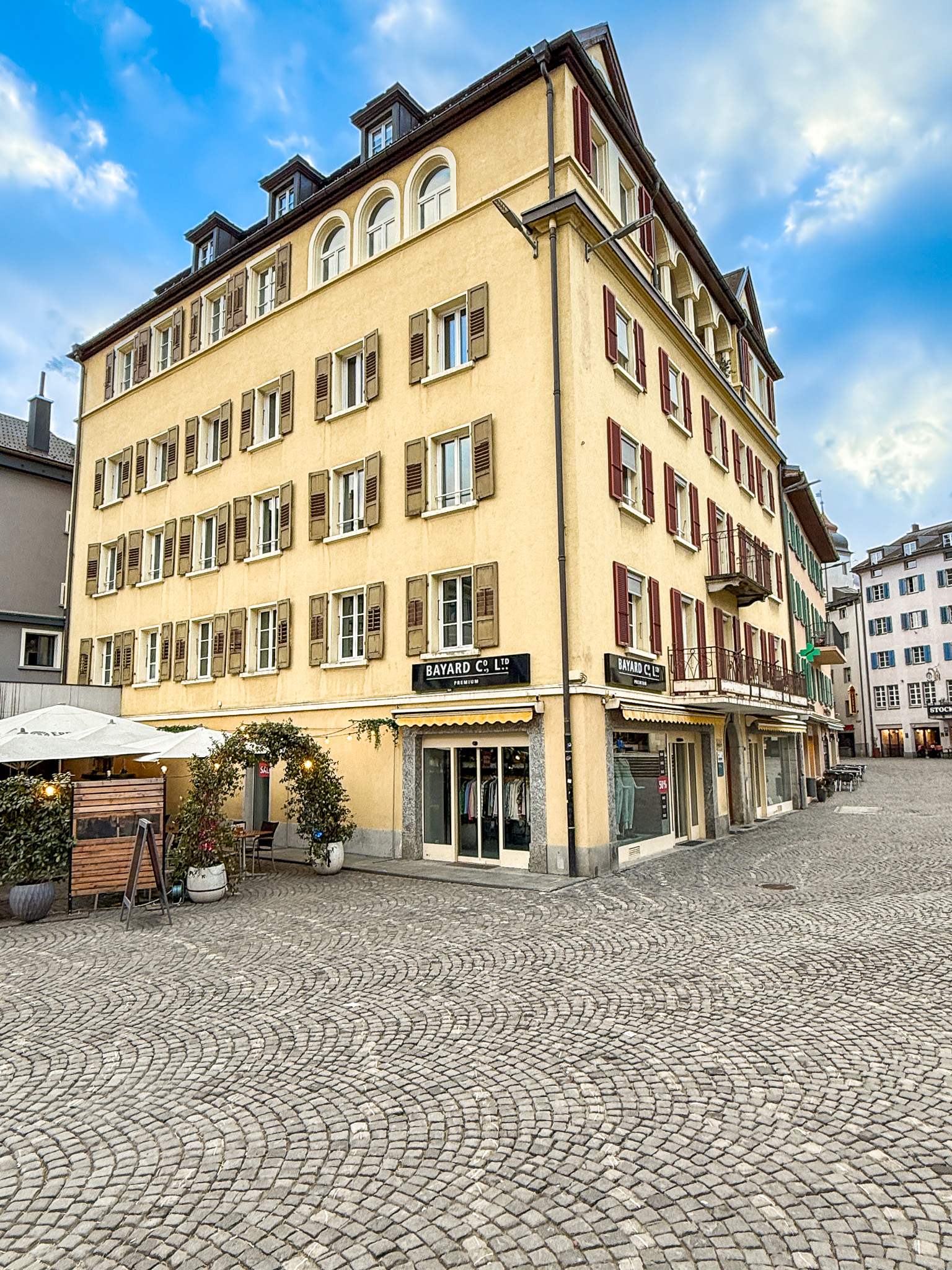 Historisches Gebäude mit Ladenfront an gepflasterter Platzsituation