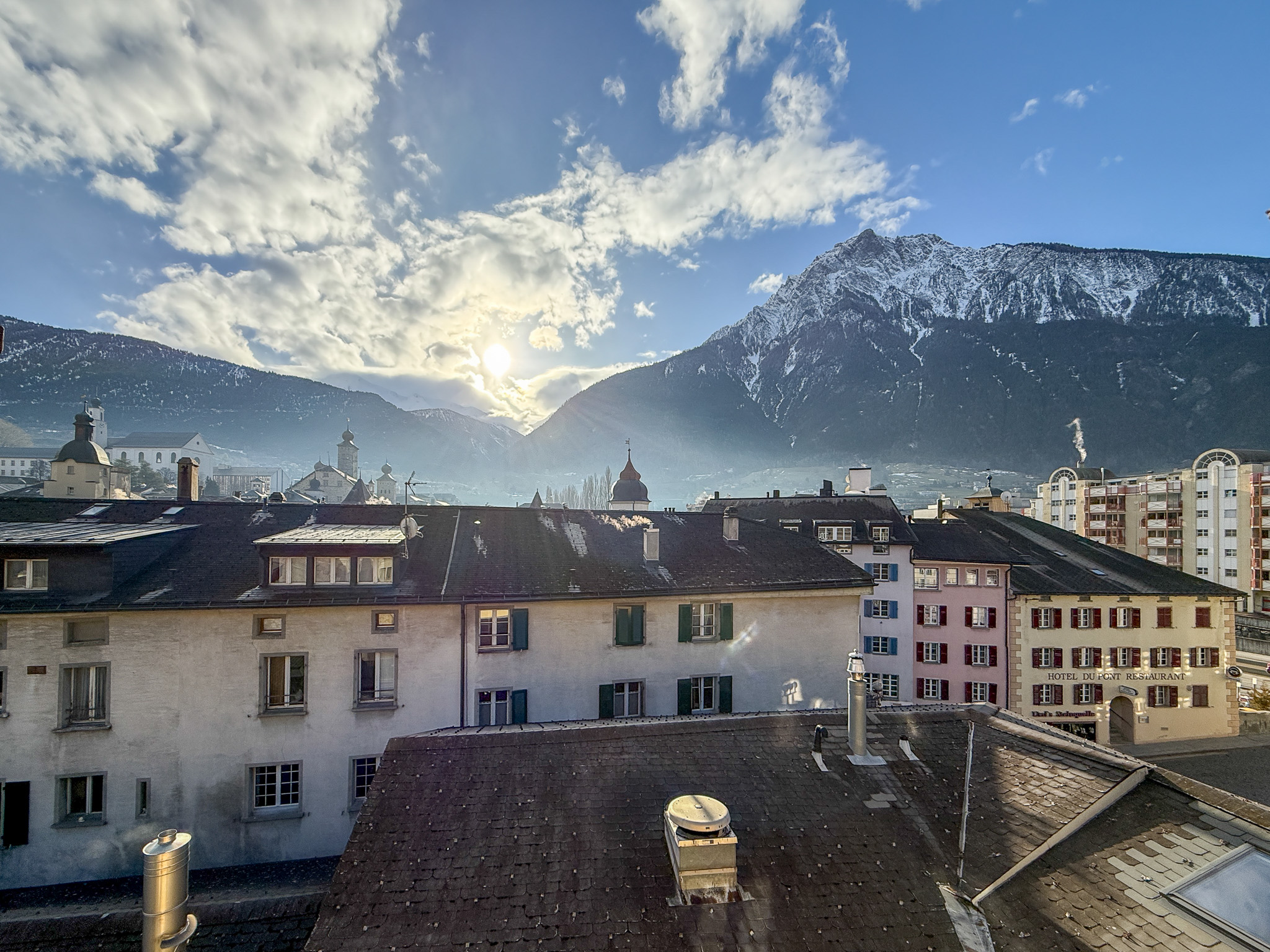 Städtischer Alpenblick mit verschneiten Bergen