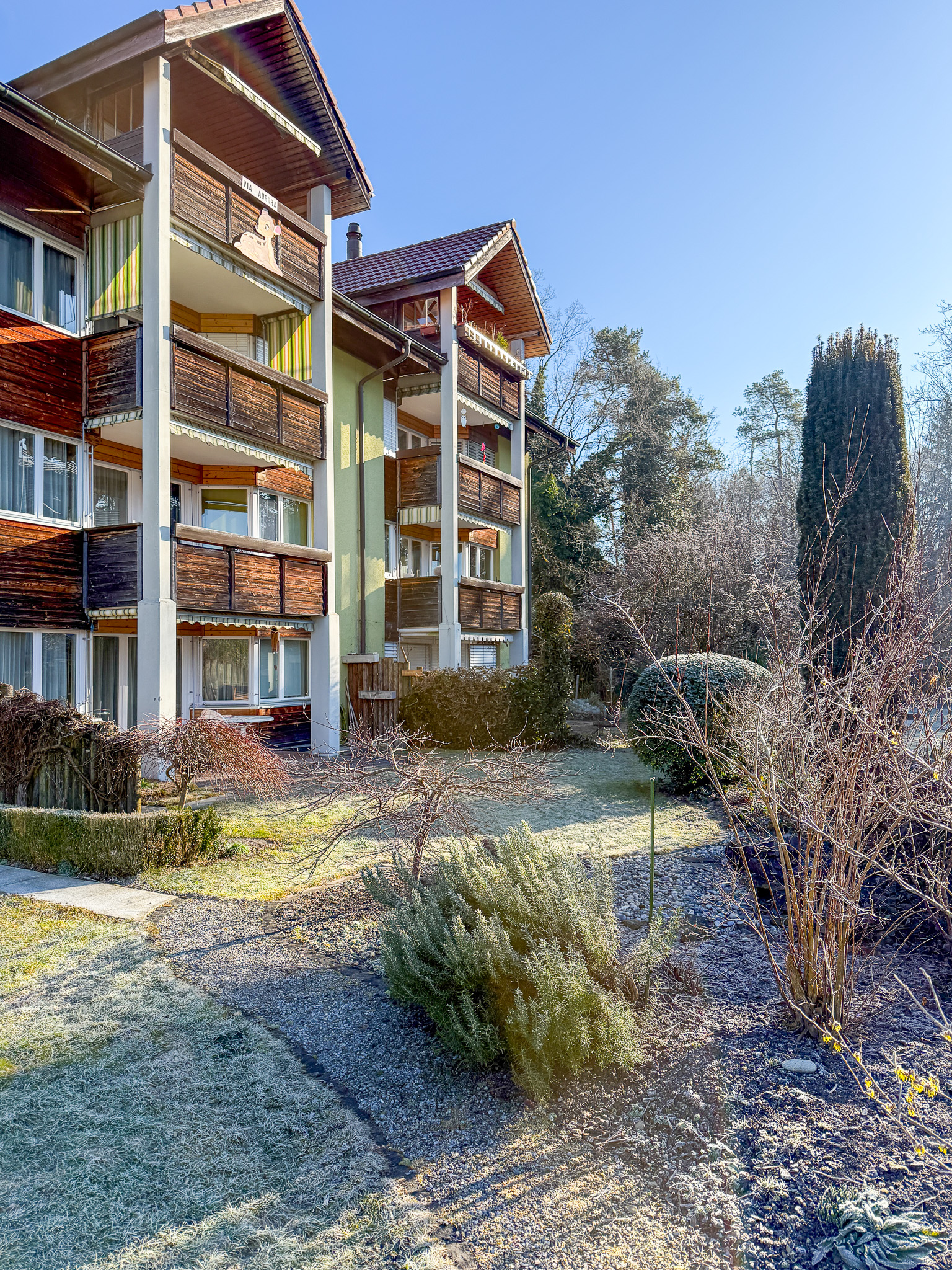 Mehrfamilienhaus mit Holzfassade und Balkon