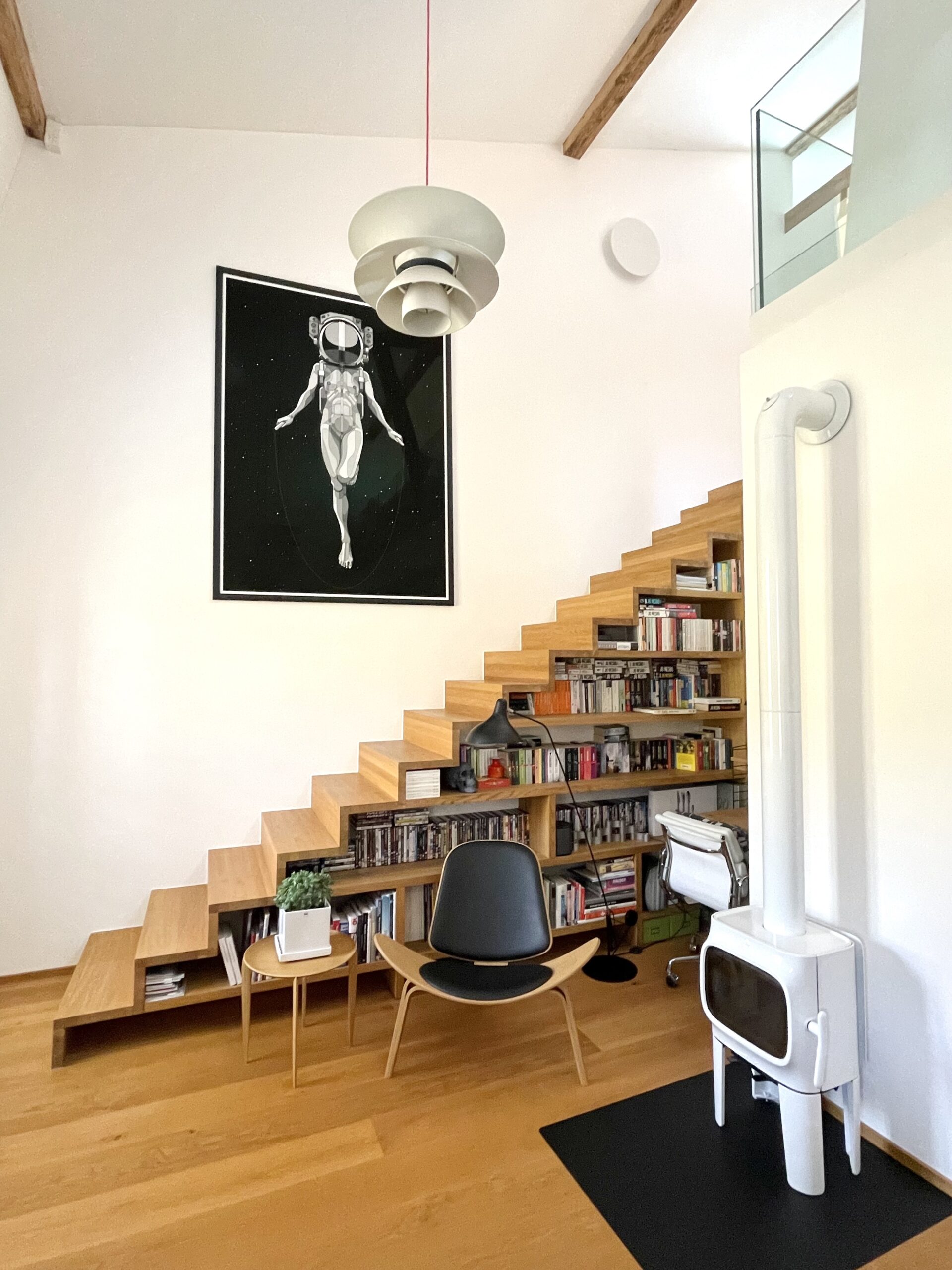 Modernes Wohn-/Arbeitszimmer mit Treppe als Regal