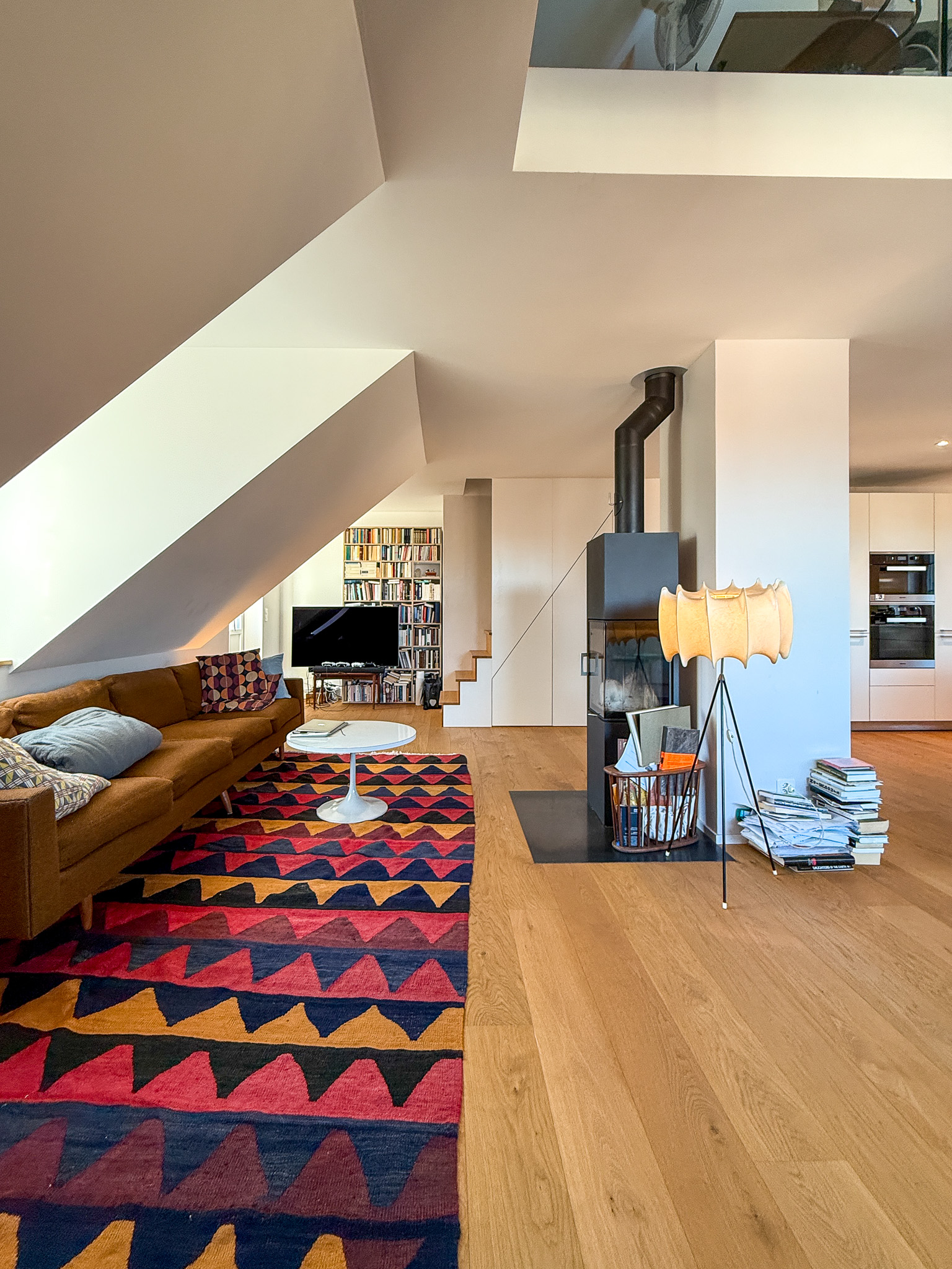 Offener Wohnbereich mit Kamin und Galerie