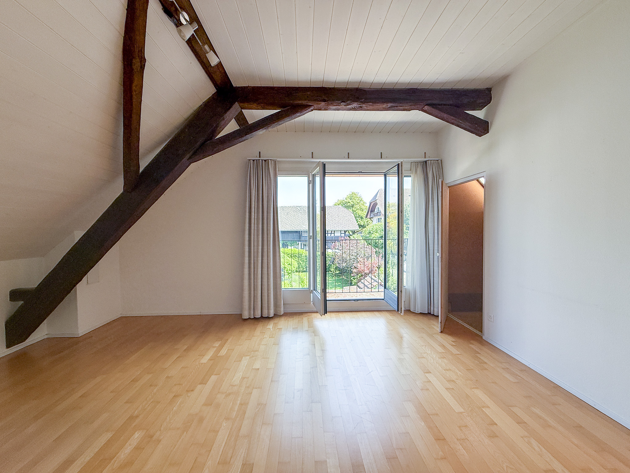 Helles Dachgeschosszimmer mit sichtbaren Holzbalken