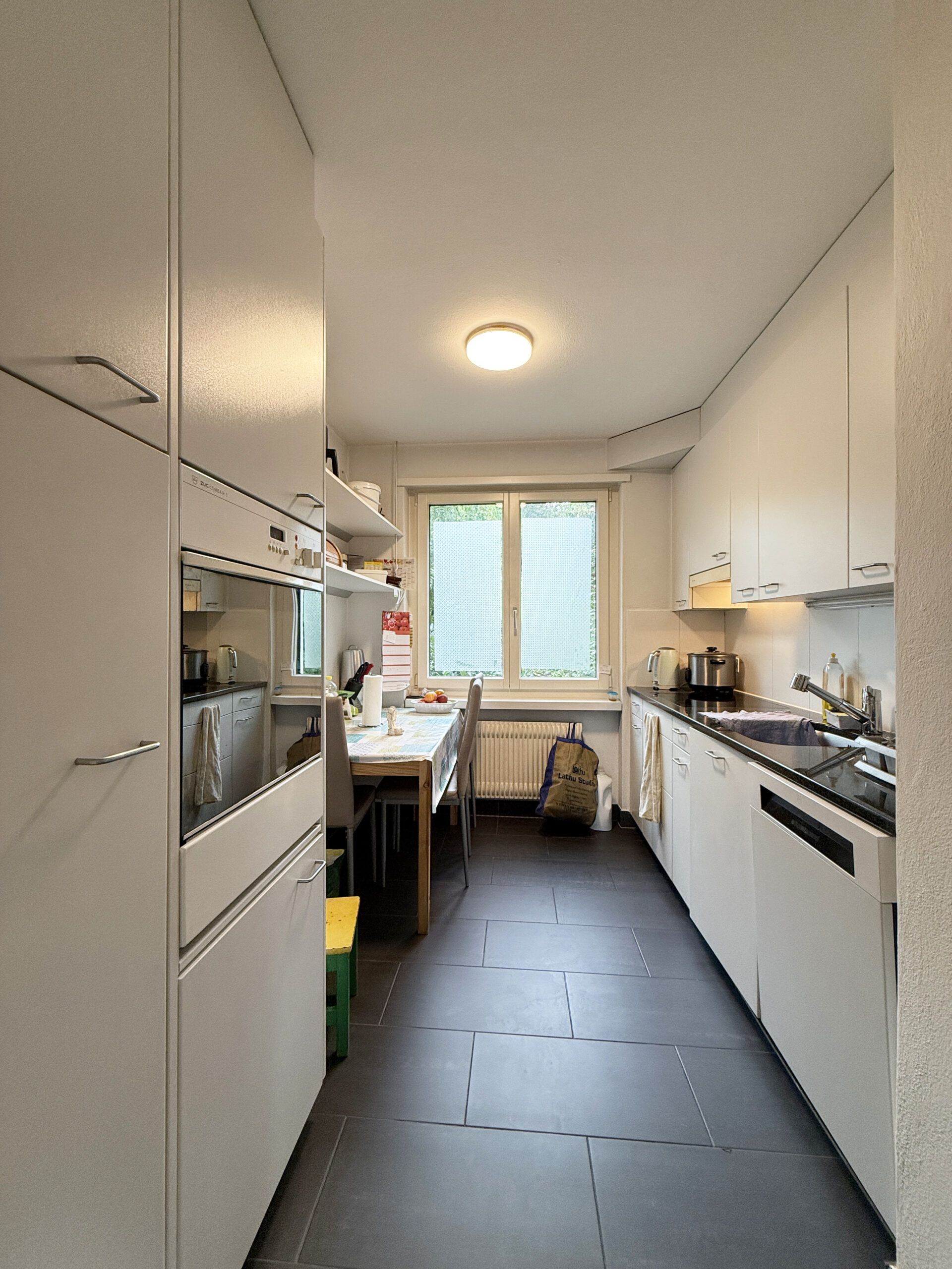 Schmale, moderne Küche mit Durchgang zum Fenster