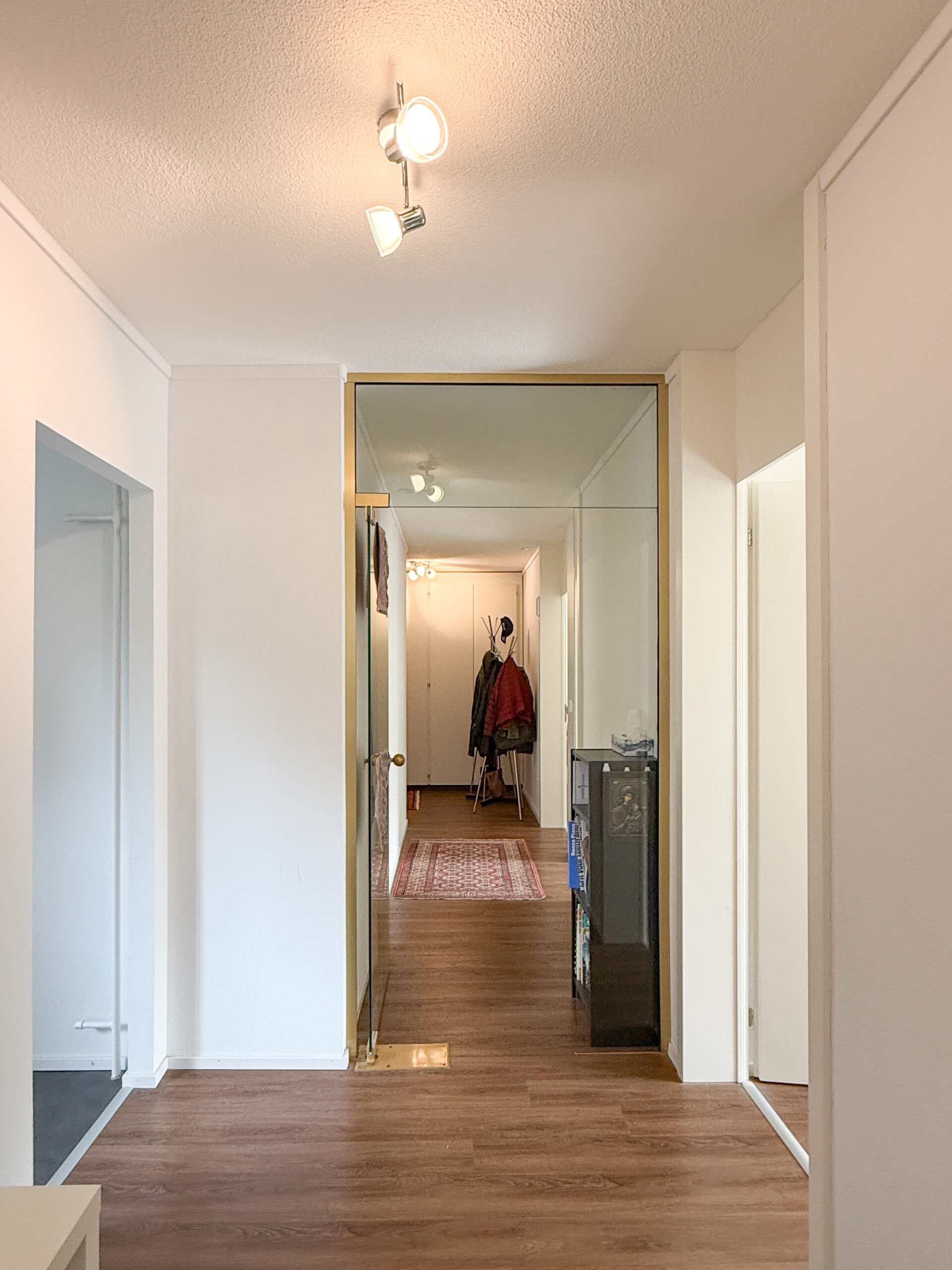 Heller Flur mit Holzoptikboden und Spiegelwand