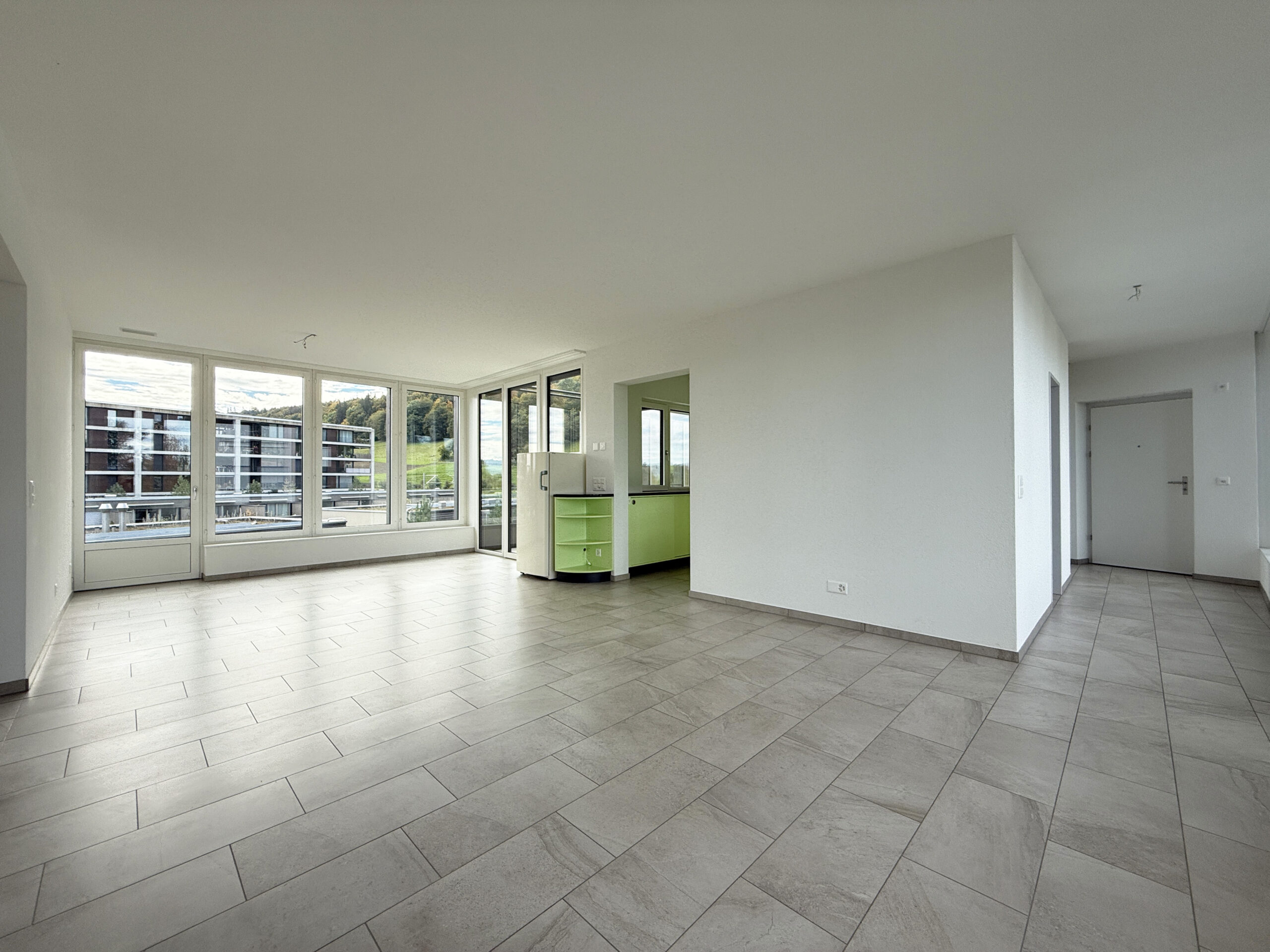 Großer leerer Wohnbereich mit Fensterfront