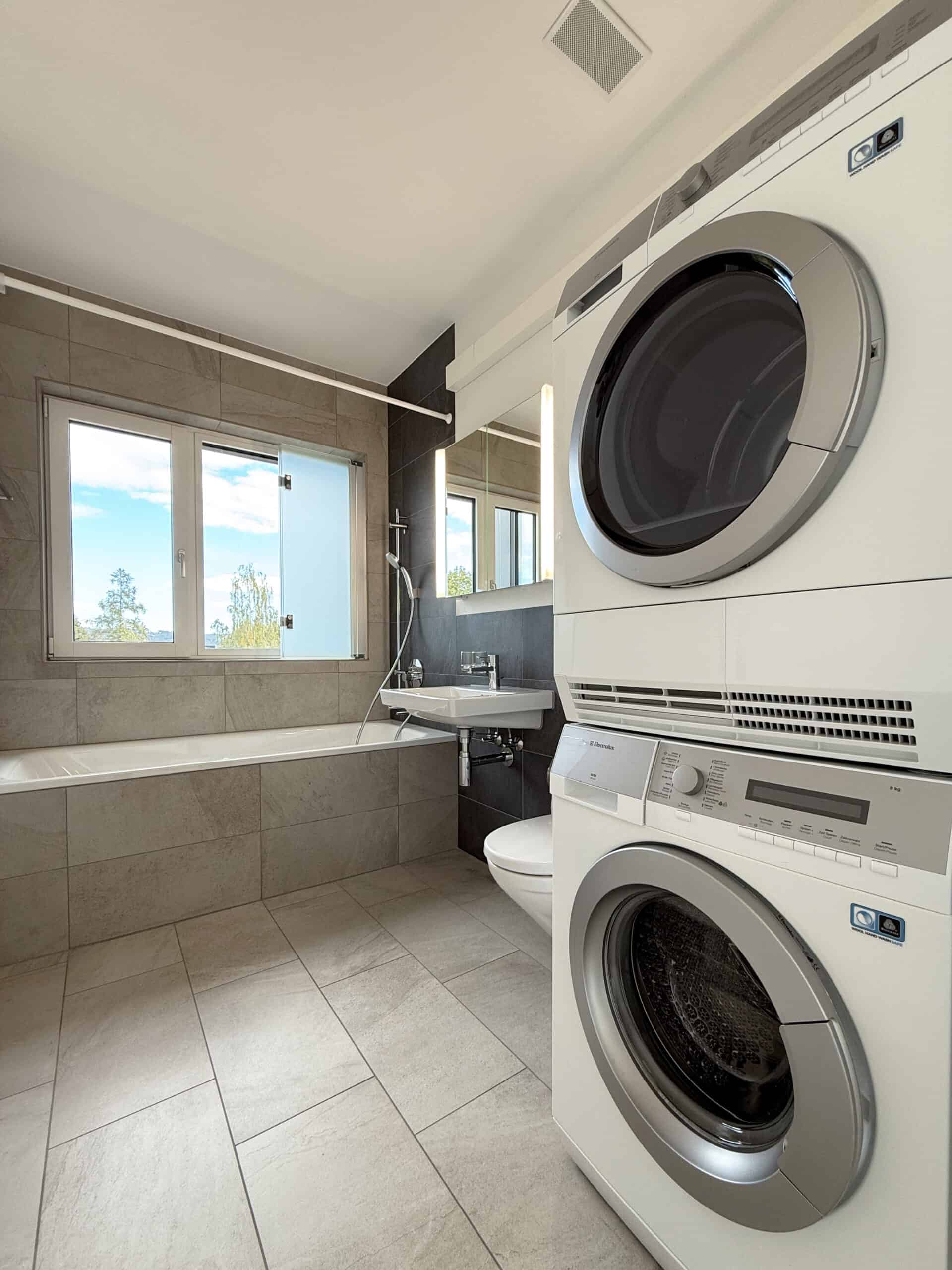 Hauswirtschaftsraum mit Badewanne und Waschmaschinen