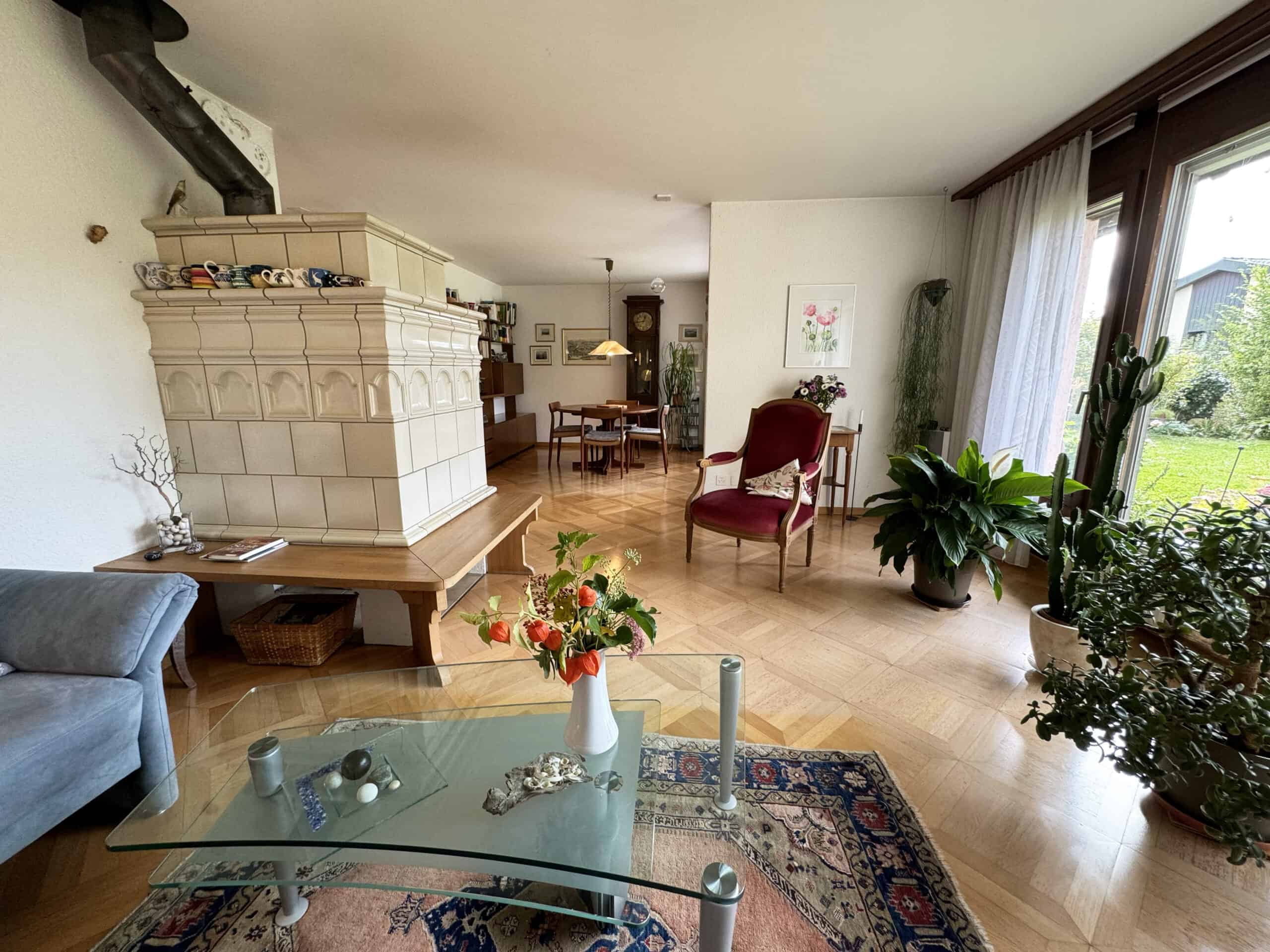 Wohnzimmer mit Kamin und Gartenblick