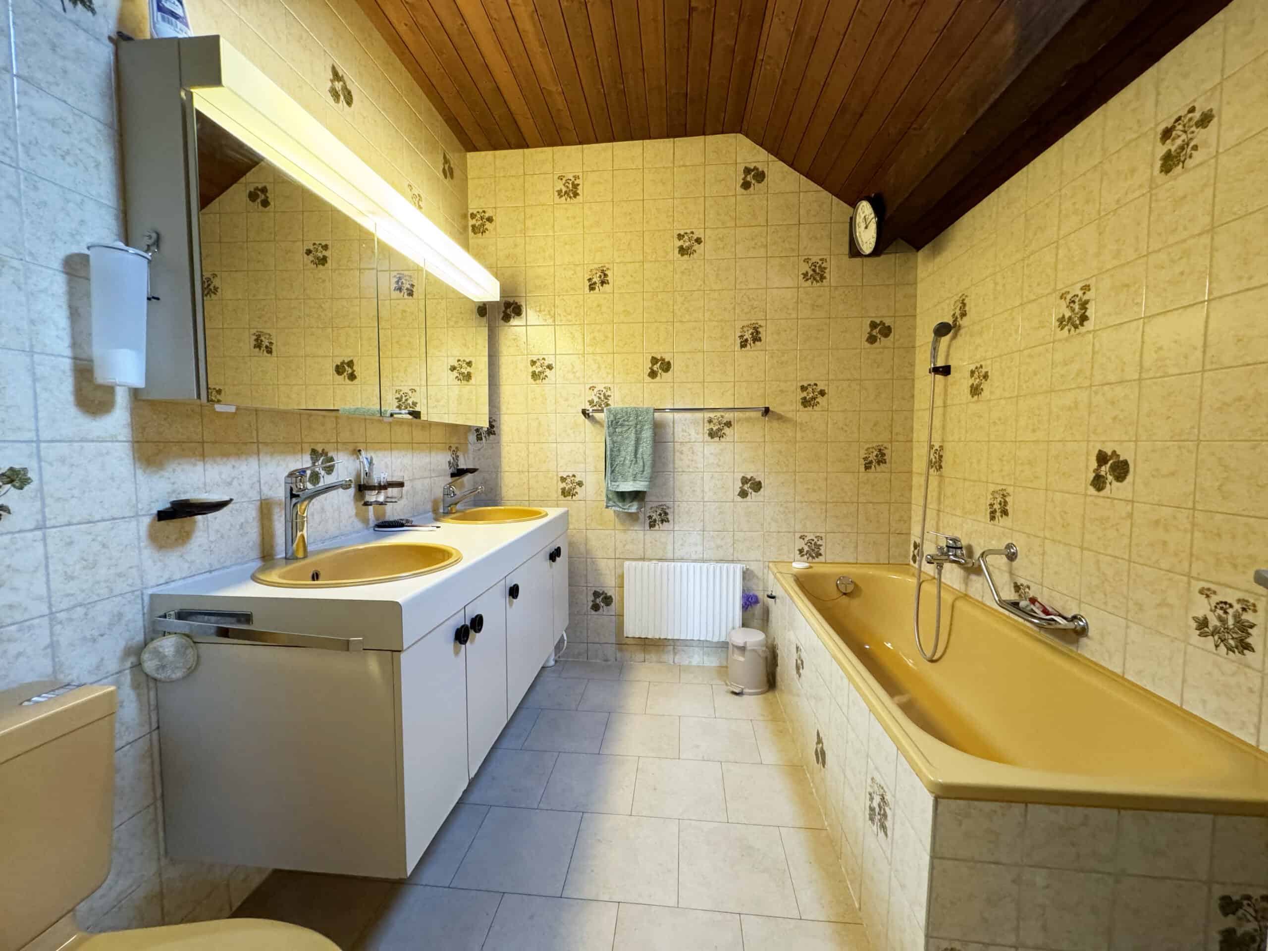 Badezimmer mit Badewanne und Doppelwaschtisch