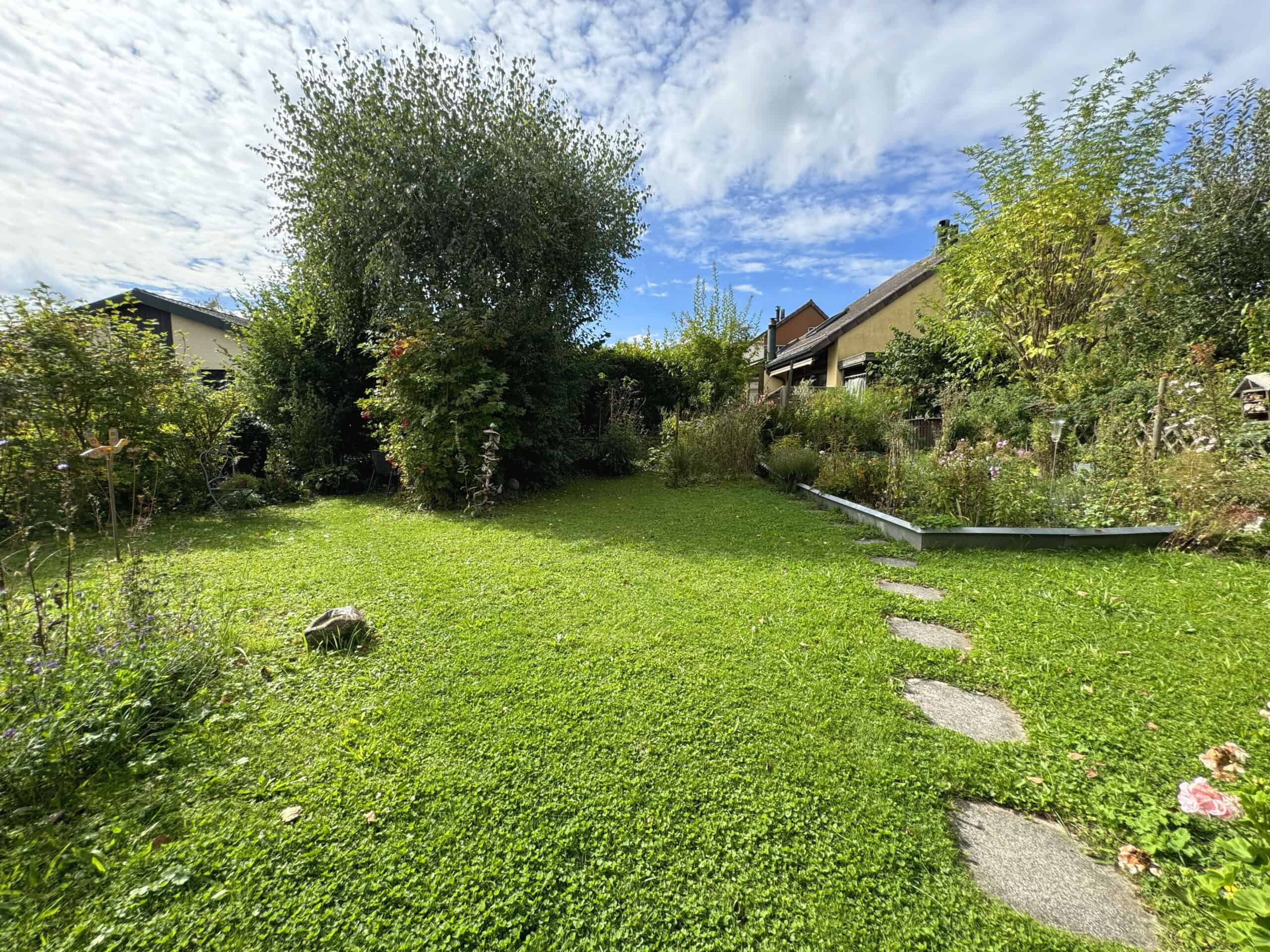Großer, grüner Garten mit Rasen und Stauden