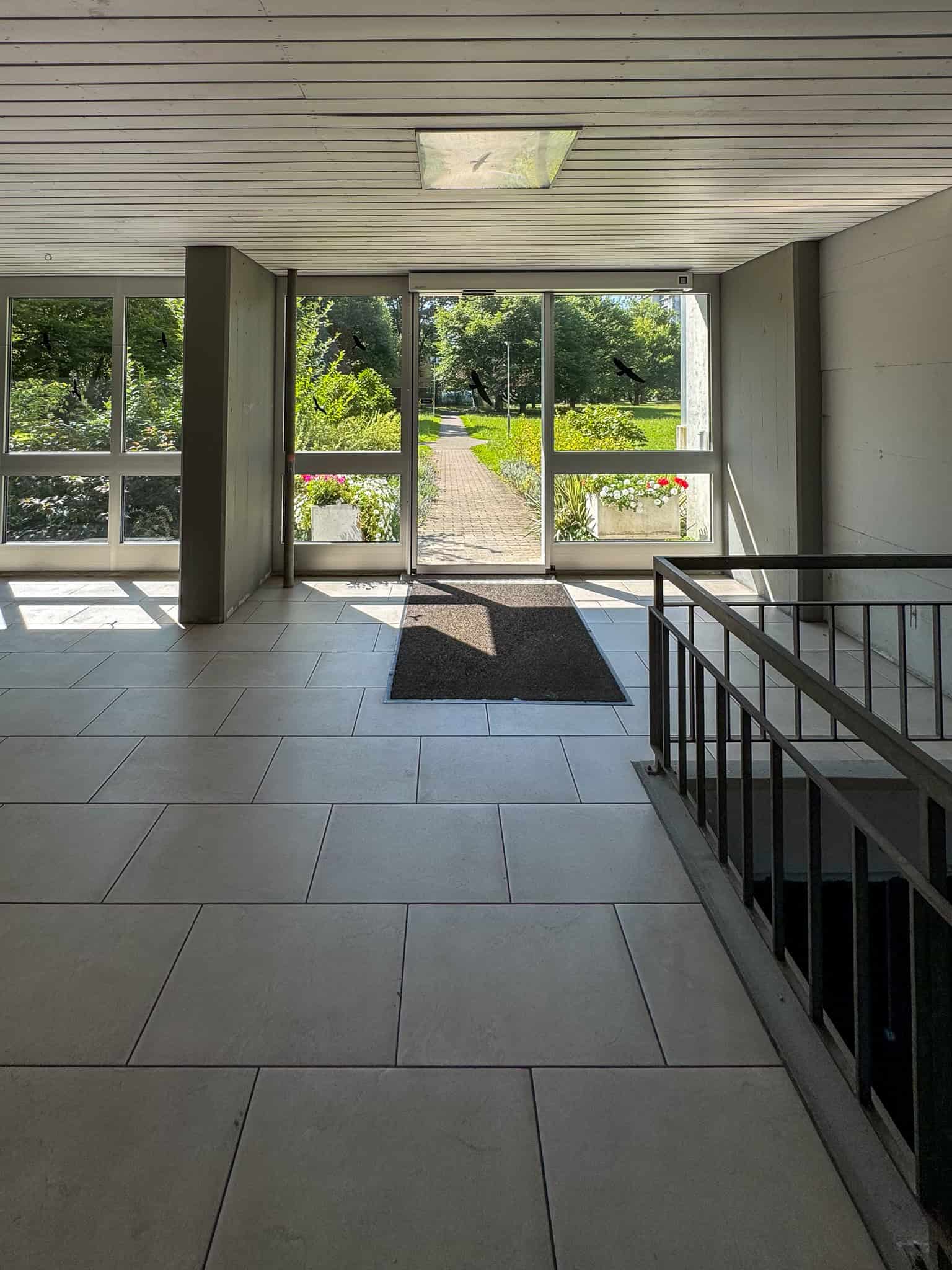 Eingangsbereich mit Glasfront und Treppe