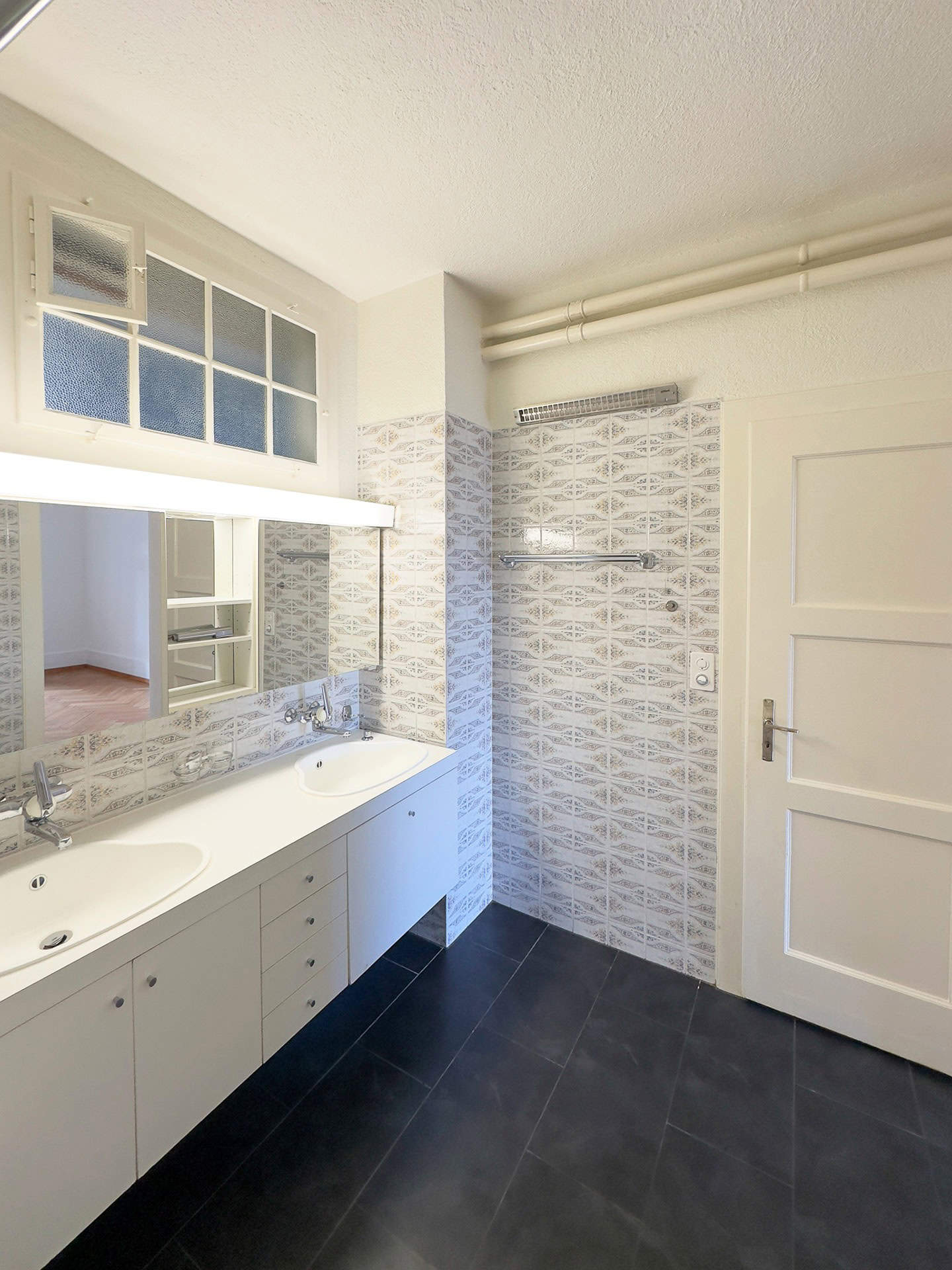 Modernes Badezimmer mit Doppelwaschbecken und gemusterten Fliesen