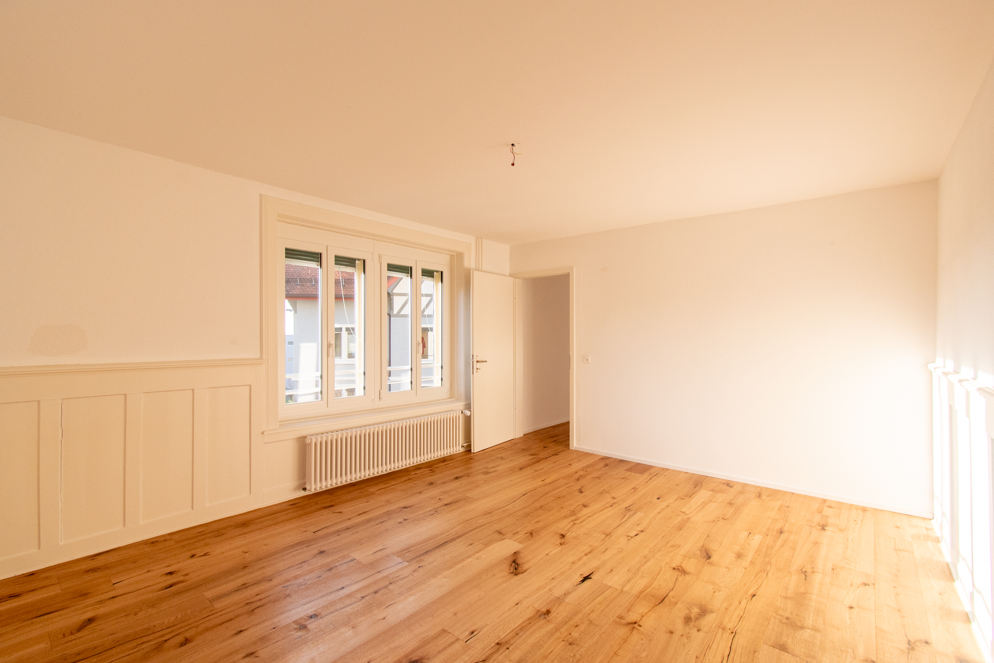Helles, leeres Zimmer mit Holzboden